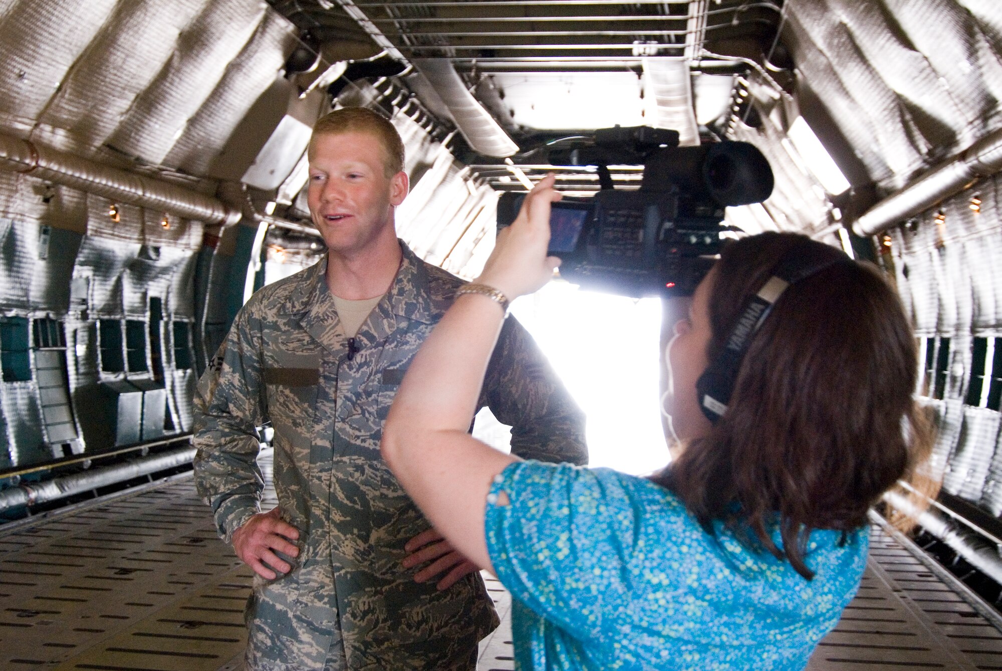 Hannah Maxwell, a production assistant for West Virginia University's Television Productions, documents an interview for a recruiting video for WVU with Senior Airman Nathan Sisler in a C-5 aircraft at the 167th Airlift Wing, Martinsburg, West Virginia, on August 27, 2009. Sisler, a WVU senior and a West Virginia Airman of the Year recipient for 2009, was chosen to be featured in the video because of his leadership qualities according to Kelly Heasley, special projects prouducer for WVU's Television Productions. (U.S. Air Force Photo by Emily Beightol-Deyerle)


