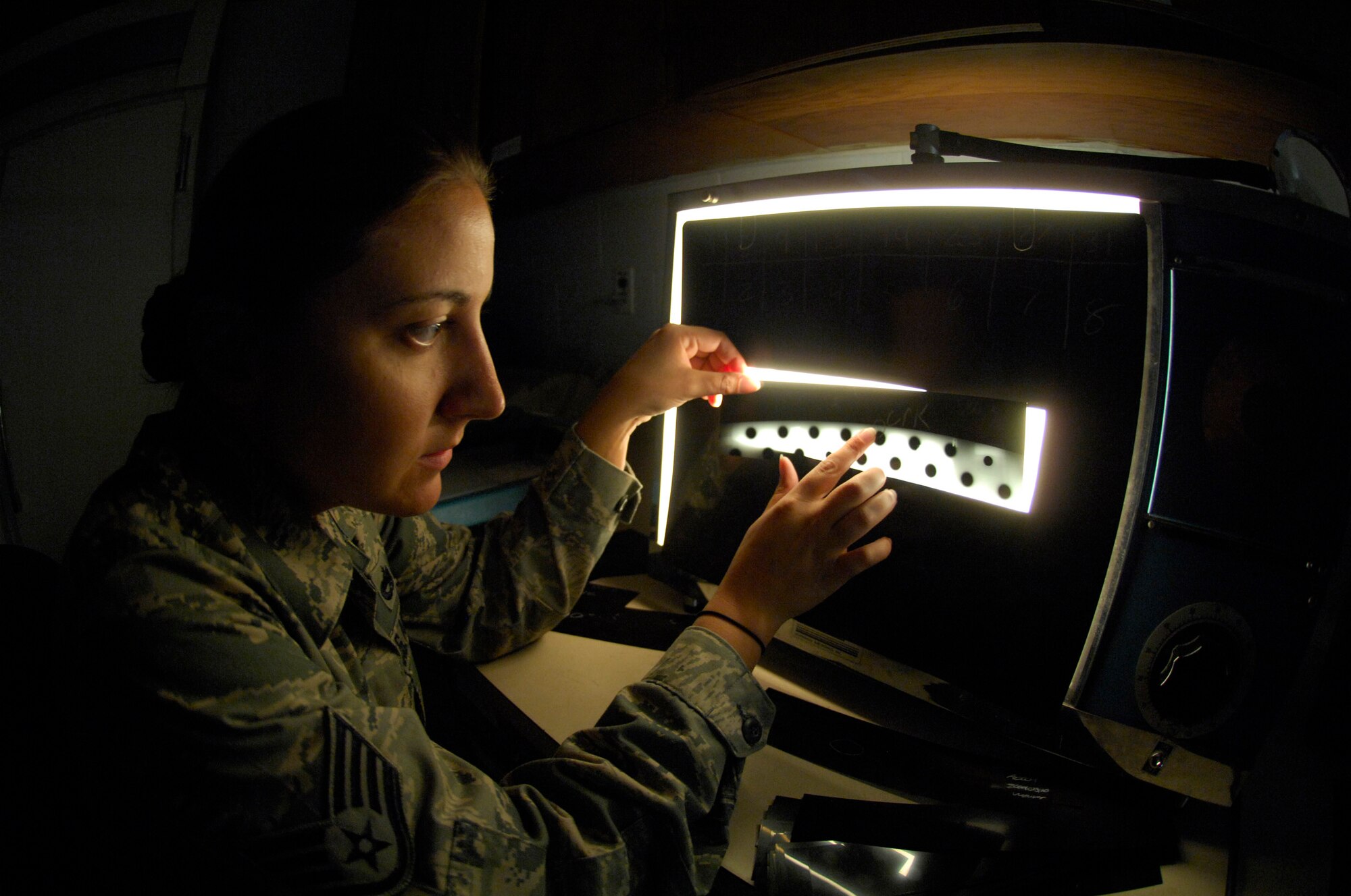 MINOT AIR FORCE BASE, N.D. -- Staff Sgt. Nadine Muro, 5th Maintenance Squadron, non-destructive inspection (NDI) non-commissioned officer in charge, examines an x-ray film strip of B-52H Stratofortress parts to track internal cracks and discontinuities within the parts here Aug. 31. NDI is the examination of aerospace weapon systems components and support equipment for structural integrity using nondestructive inspection methods and fluid analysis. (U.S. Air Force photo by Airman 1st Class Jesse Lopez)