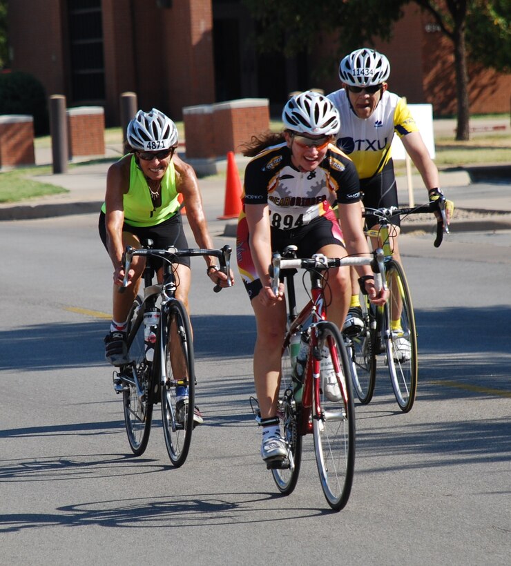 Three cyclists ride through Sheppard in the Hotter N’ Hell bike race, largest international bicycle race Aug. 29. About 14,200 athletes participated in the race, breaking the records for the number of participants in the race and the number of volunteers from Sheppard. About 2000 Sheppard members volunteered to provide rest stops, medical assistance, set-up and teardown support to make the race possible. (U.S. Air Force photo/Airman 1st Class Adawn Kelsey) 