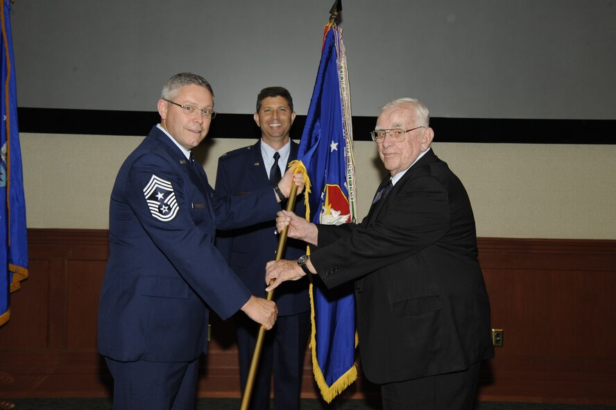 927th Command Chief Master Sergeant Clifford Whitenburg hands his flag to Mr. Bob Cutler (USAF Retired) during the Honorary Commanders Ceremony (U.S. Air Force Photo/Staff Sgt. Swafford)