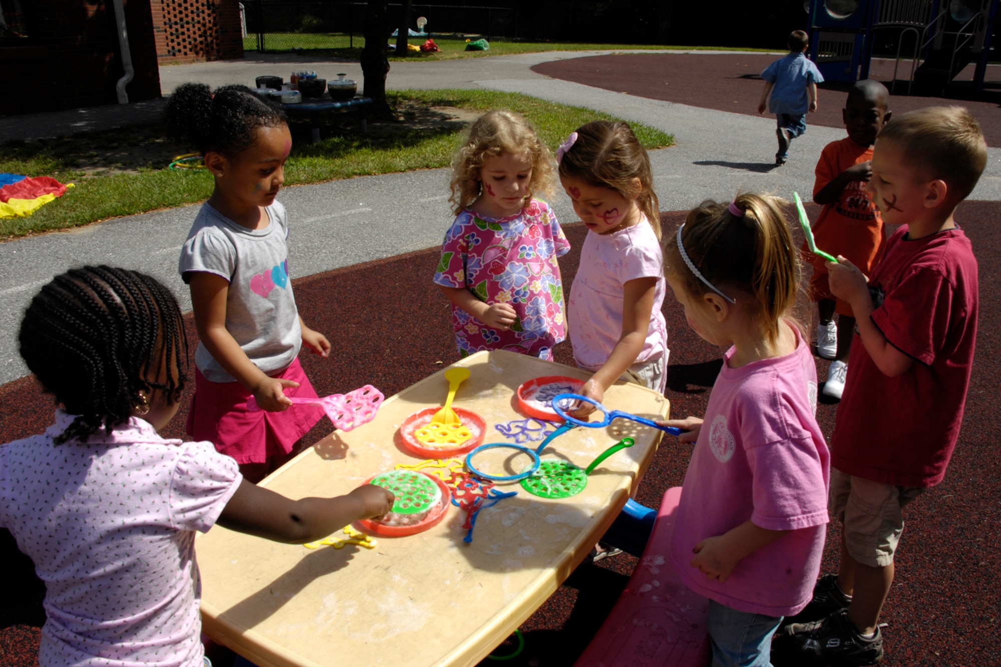 HANSCOM AIR FORCE BASE, Mass. – Children enrolled at the Hanscom Child Development Center stop at the bubble making station during the annual summer carnival event that took place Aug. 25. The carnival included face painting, games, and activities for children and their parents to enjoy. (U.S. Air Force photo by Linda LaBonte Britt)