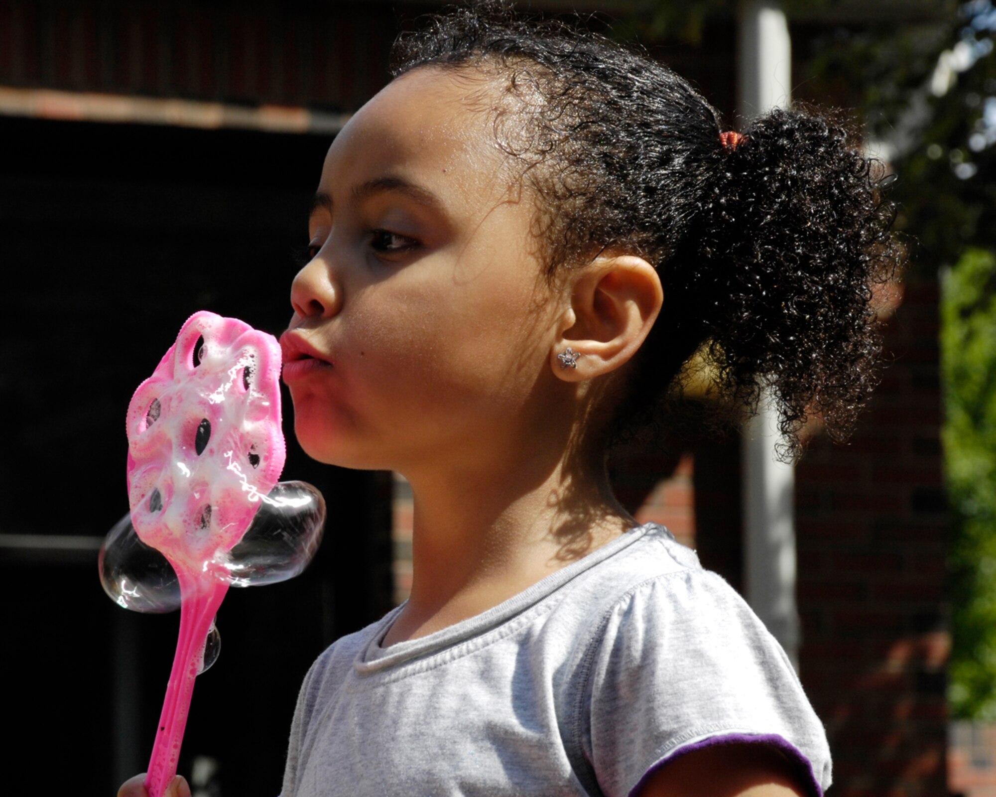 HANSCOM AIR FORCE BASE, Mass. – Geraldine Arcelay blows a bubble at one of the activity stations set up for children to enjoy during the Child Development Center’s summer carnival on Aug. 25. (U.S. Air Force photo by Linda LaBonte Britt)
