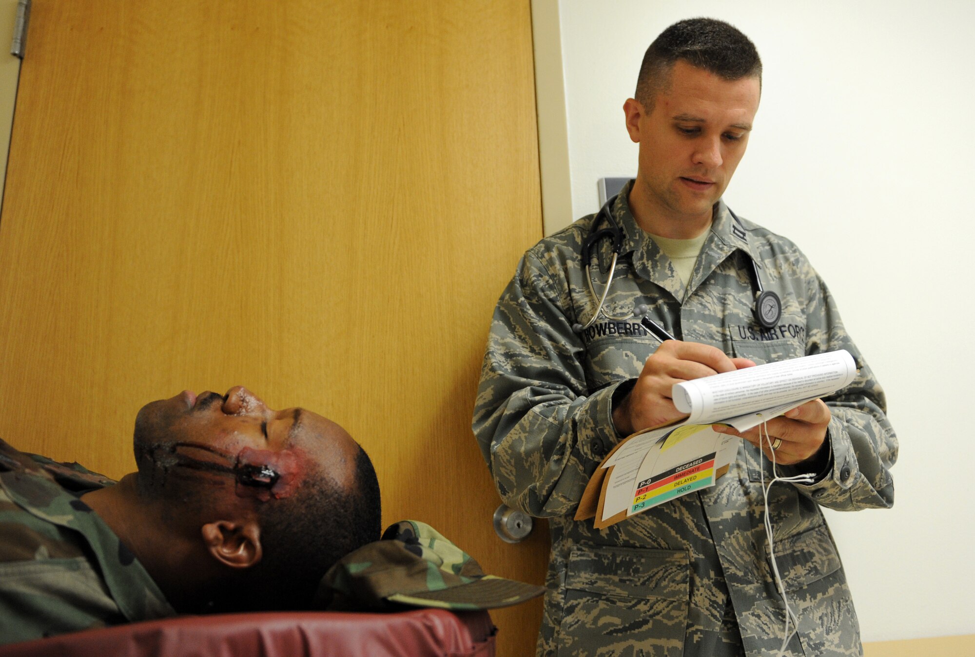 MOUNTAIN HOME AIR FORCE BASE, Idaho – Captain Justin Rowberry, 366th Medical Operations Squadron staff pediatrician, assesses the “injuries” of Senior Airman Brandaun James, 366th Medical Group outpatient records journeyman, during an exercise Aug. 25. Moulage exercises enhance realism and allow first responders to practice self aid and buddy care while getting used to seeing injuries. (U.S. Air Force photo by Airman 1st Class Debbie Lockhart)
