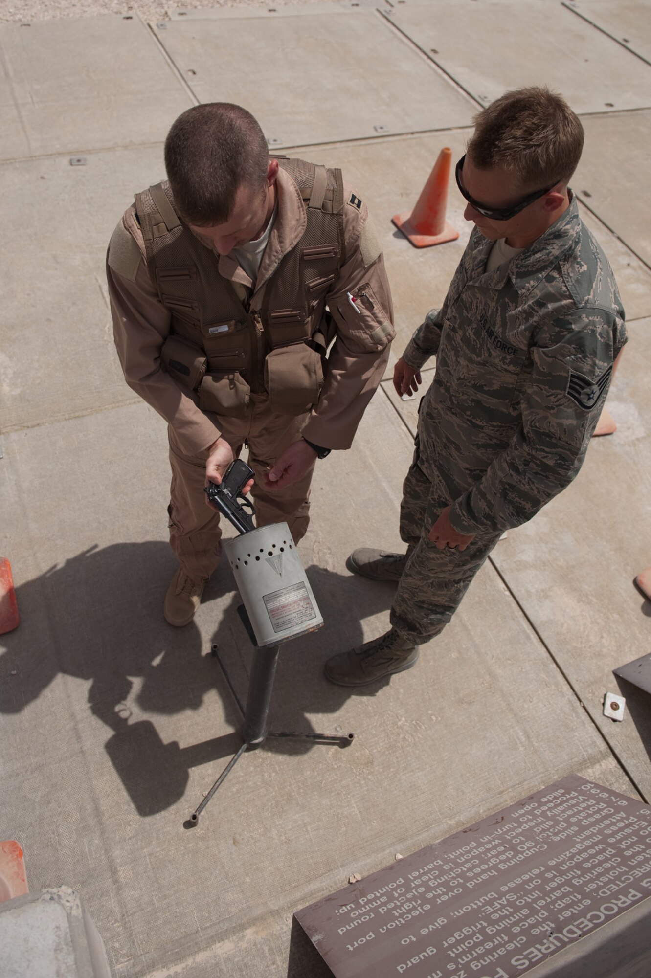 Right, Sergeant Charles Crooks, 379th Expeditionary Operations Support Squadron aircrew flight equipment journeyman, issues a B-1B Lancer crew member an M-9 pistol, Aug. 28, in Southwest Asia. Sergeant Crooks assists with the safety of aircrew by providing personal protective equipment and survival gear. Sergeant Crooks is deployed from Ellsworth Air Force Base, S.D. in support of Operations Iraqi and Enduring Freedom. (U.S. Air Force photo/Staff Sgt. Robert Barney)