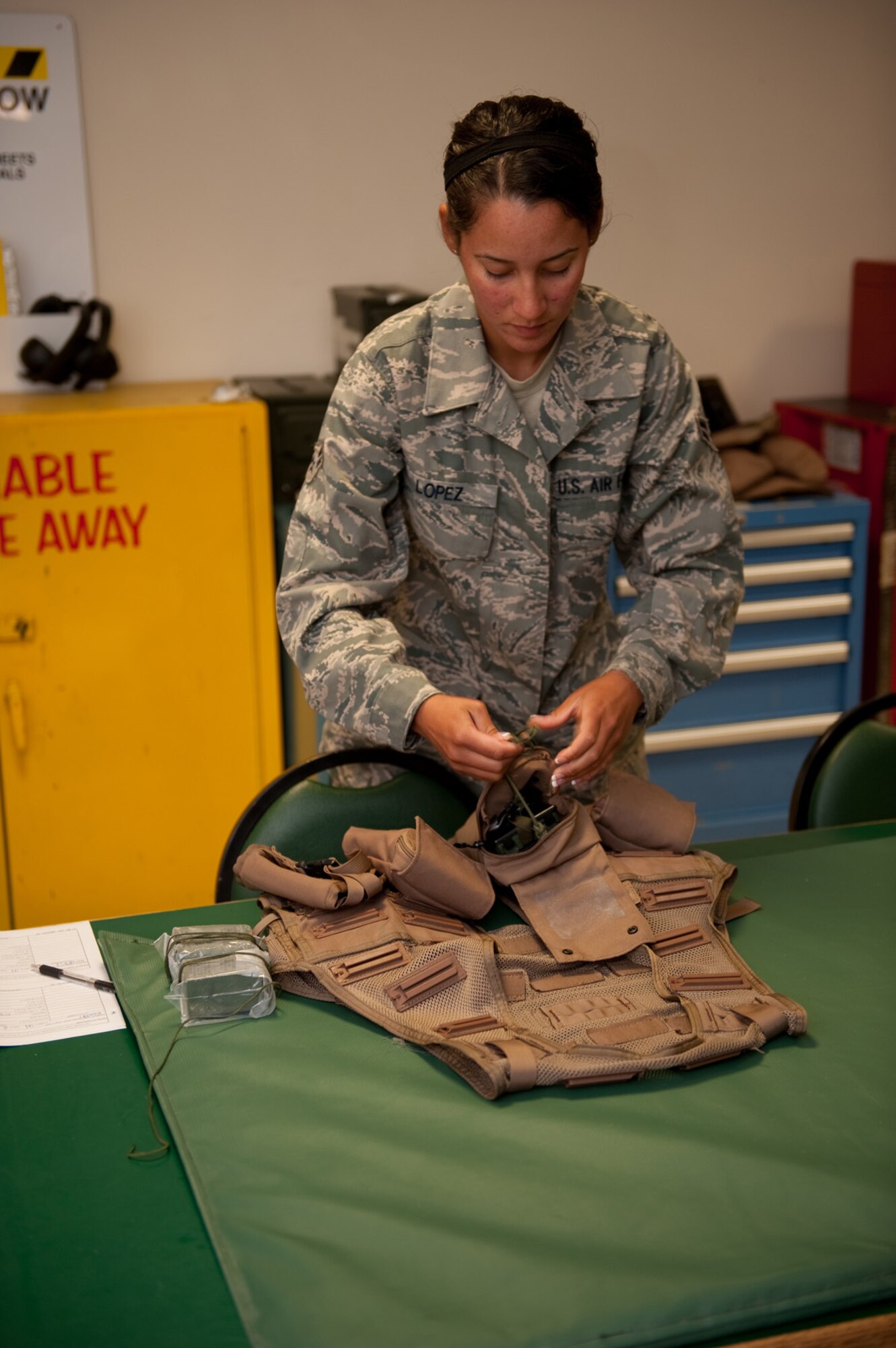 Airman 1st Class Jennifer Lopez, 379th Expeditionary Operations Support Squadron aircrew flight equipment journeyman, prepares and checks survival vests prior to being issued to a B-1B Lancer crew, Aug. 28, in Southwest Asia. Airman Lopez assists with the safety of aircrew by providing personal protective equipment and survival gear. Airman Lopez is deployed from Ellsworth Air Force Base, S.D. in support of Operations Iraqi and Enduring Freedom. (U.S. Air Force photo/Staff Sgt. Robert Barney)