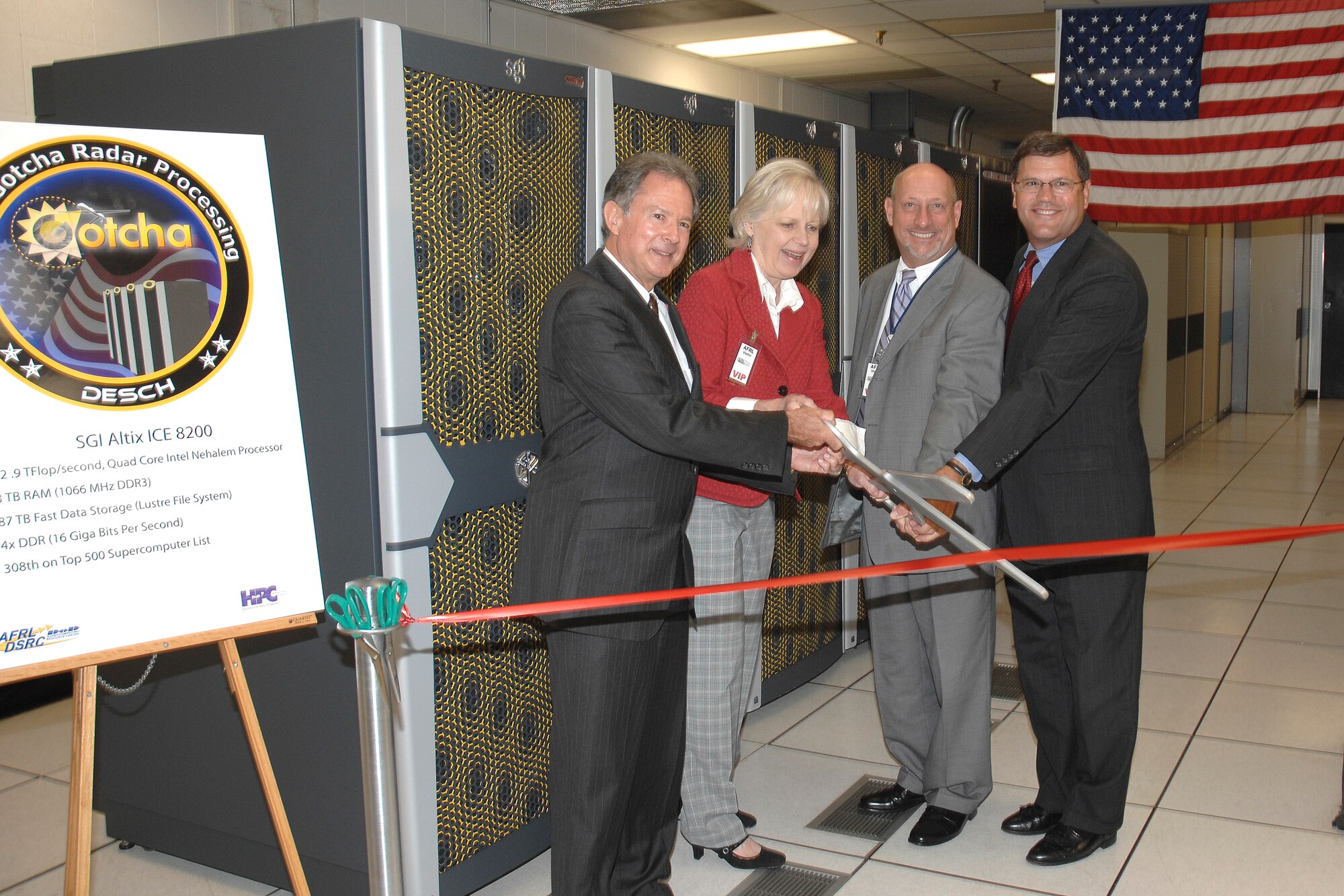Distinguished visitors dedicate Desch, an SGI Altix ICE 8200 supercomputer, during a ribbon cutting ceremony August 31 at Wright-Patterson Air Force Base.  The new supercomputer is named after Joseph Desch, a Dayton, Ohio engineer who developed computing machines during World War II to decipher German Enigma-coded communications.  It will be used to translate real-time synthetic aperture radar data from the Gotcha radar system being developed by the Air Force Research Laboratory into high-resolution 3D images.  Pictured from left to right are Dr. David Jerome, director of the Air Force Research Laboratory Sensors Directorate; Deborah Desch Anderson, daughter of Joseph Desch; Dr. Michael Kuliasha, AFRL chief technologist; Jim Brinker, vice president of SGI Federal Service. (U.S. Air Force photo/William Pugh)