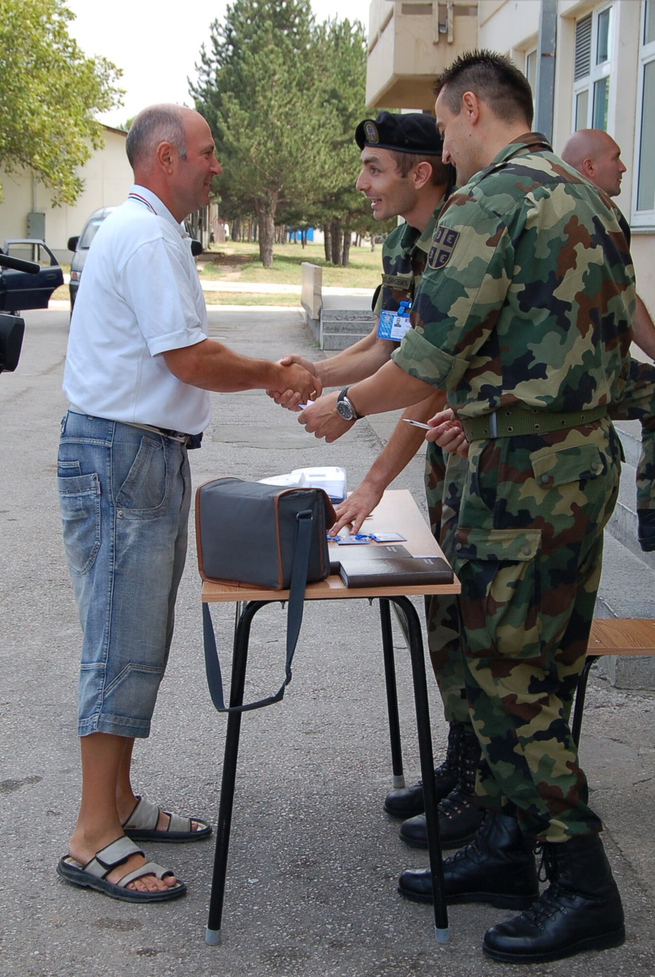 NIS, Serbia – Senior Sergeant Milos Miladinovic, Serbian Armed Forces Force Protection (left), shakes hands with a representative of the Republic of Macedonia Aug. 31 as a fellow SAF member stands by during in-processing into the military medical training exercise in Central and Eastern Europe, better known as MEDCEUR 2009, in Nis, Serbia. (U.S. Air Force photo/Senior Airman Kali L. Gradishar)