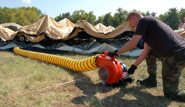 NIS, Serbia – Staff Sgt. Kevin Welch, 435th Air Mobility Squadron from Ramstein Air Base, Germany, hits the switch to an air compressor Aug. 29 while setting up a morale tent for participants in the military medical training exercise in Central and Europe, better known as MEDCEUR 2009, in Nis, Serbia. A large balloon-type device inflated under a tent pushes the tent ceiling up, making it easier to construct the tent. (U.S. Air Force photo/Senior Airman Kali L. Gradishar)