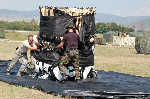 NIS, Serbia – Chief Master Sgt. Ed Madden, 435th Contingency Response Group superintendent from Ramstein Air Base, Germany, and other members of the group push a tent to the center of an inflatable device used to ease the set up of large tent facilities Aug. 29. As the inflatable device inflates, the tent ceiling is lifted off the ground. A tent city, to include sleeping and morale tents, was set up for participants in the military medical training exercise in Central and Europe, better known as MEDCEUR 2009, in Nis, Serbia. (U.S. Air Force photo/Senior Airman Kali L. Gradishar)