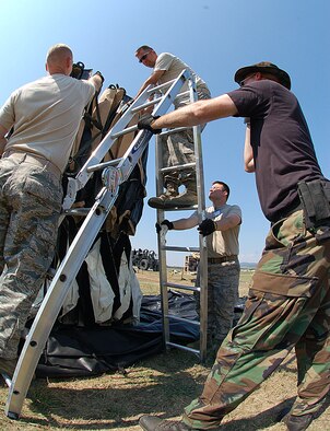 NIS, Serbia – Master Sgt. Ryan Leith unhooks straps from a tent as others stabilize the ladder while constructing a morale tent Aug. 29 for participants in the military medical training exercise in Central and Europe, better known as MEDCEUR 2009, in Nis, Serbia. Members of the U.S. Air Force and Serbian Armed Forces set up tents and other facilities for use of the participants in the exercise scheduled for Sept. 2-13. (U.S. Air Force photo/Senior Airman Kali L. Gradishar)