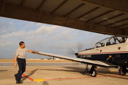Rick Peterson a T-6 Texan II Crew Chief assigned to the 12th Maintenance Squadron, Randolph Air Force Base, Texas, conducts a final of the aircrafts control surfaces prior to a Pilot Instructor Training mission. (U.S. Air Force photo/Steve Thurow)