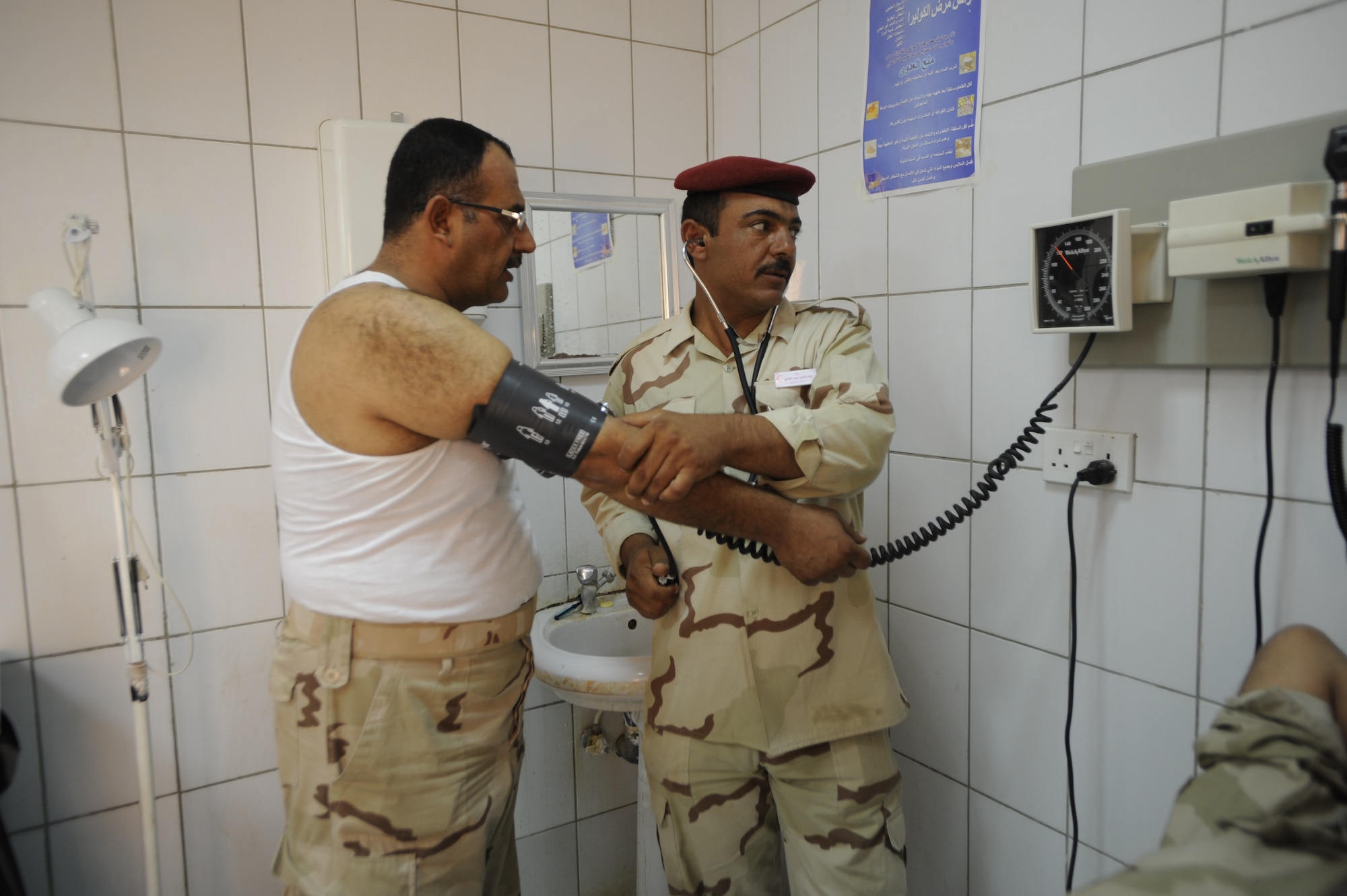 An Iraqi Army medical technician examines a fellow soldier Aug. 17, 2009 at Camp Ur, Iraq. (U.S. Air Force photo by Staff Sgt. Shawn Weismiller / Released)