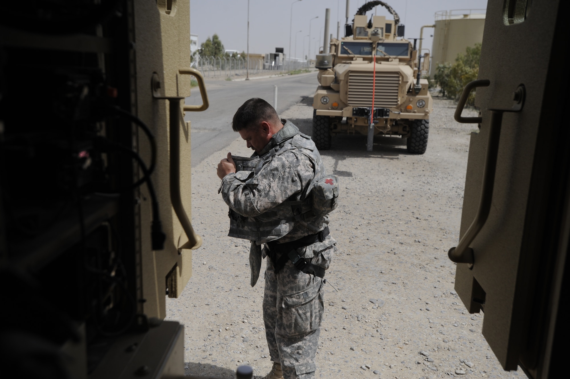 ALI BASE, Iraq - U.S. Air Force Lt. Col. Steven Ramsay, Tallil Logistics Military Advisory Team (LMAT) Senior Advisor, dons a harness in preparation for a convoy to Contingency Operating Base Adder, Iraq, from Camp Ur, an Iraqi military base Aug. 17, 2009.  Colonel Ramsay, deployed from Keesler Air Force Base, Miss., and his team advise their Iraqi military counterparts on base operations. (U.S. Air Force photo / Staff Sgt. Shawn Weismiller )