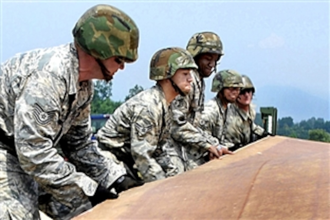 U.S. Air Force airmen unfold a fiberglass mat on the simulated runway before it is put into place
on Jungwon Air Base, South Korea, Aug. 19, 2009. The airmen are assigned ot the 51st Civil Engineer Squadron. The 30-foot long, 54-foot wide foot mats are used to quickly repair runway damage.
