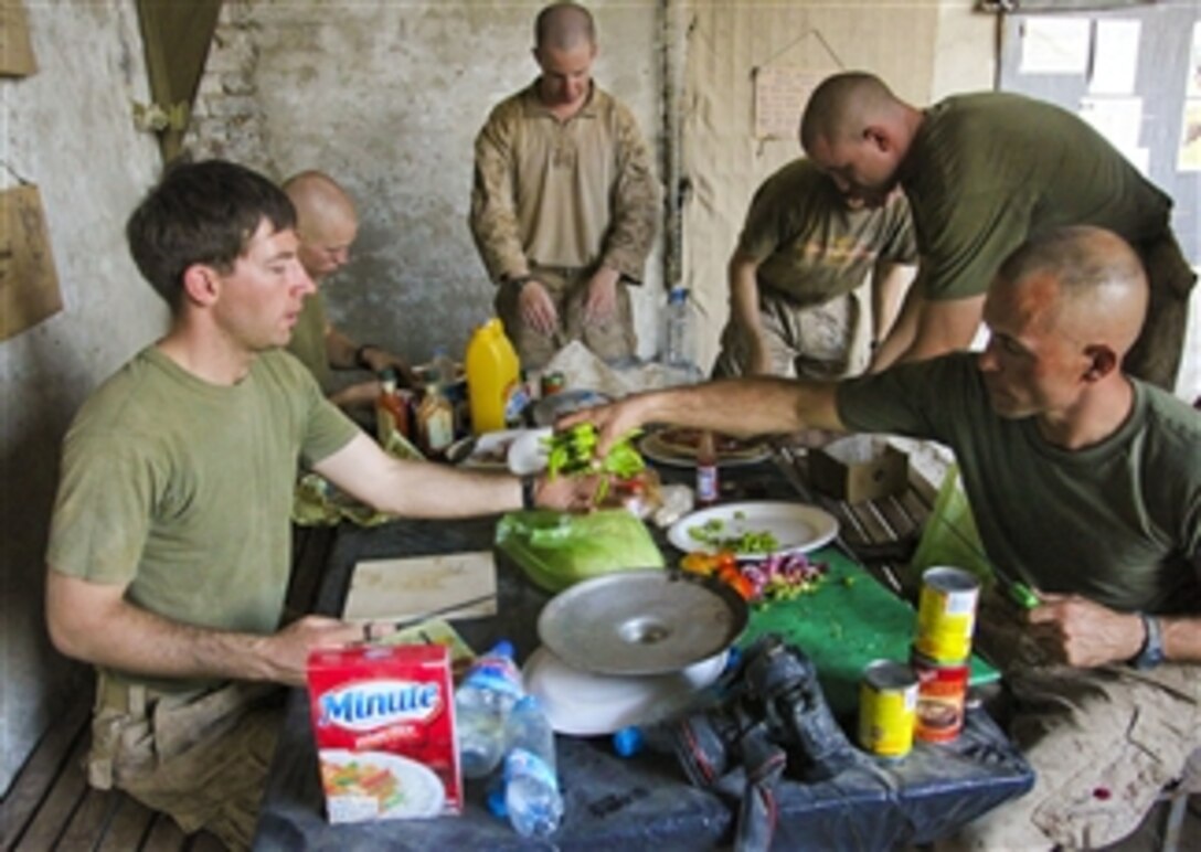 U.S. Marines with 1st Battalion, 5th Marine Regiment prepare food for dinner at Patrol Base Jaker, Afghanistan, on Aug. 25, 2009.  