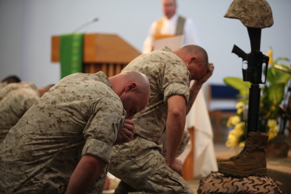 Marines with 1st Tank Battalion bow their heads in prayer during a memorial service in honor of Lance Cpl. Adam Lynch, a vehicle commander with 1st Tanks Headquarters and Service Company, at the Combat Center's Catholic Chapel Sept. 2.