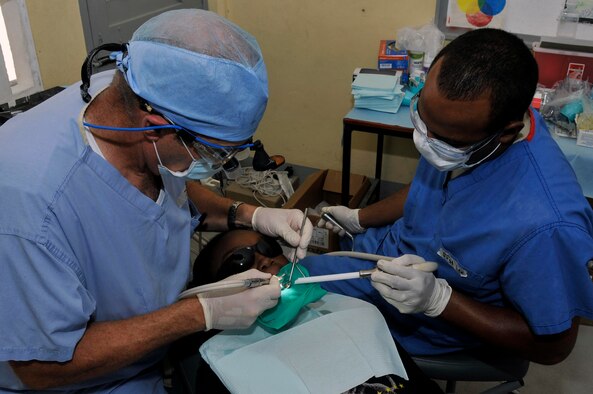 Lt. Col. (Dr.) Darryl Bybee, dentist, 75th Dental Squadron, Hill AFB, and Staff Sgt. Joseph Lee, dental technician from 47th Medical Operations Squadron, Laughlin AFB, performs a filling on Guyanese women Aug. 24, 2009, at the Diamond Secondary School, in Diamond, Guyana. Lt. Col. Bybee spent 31 years in his own private practice before joining the Air Force through direct commission. (U.S. Air Force photo by Airman 1st Class Perry Aston) (Released)