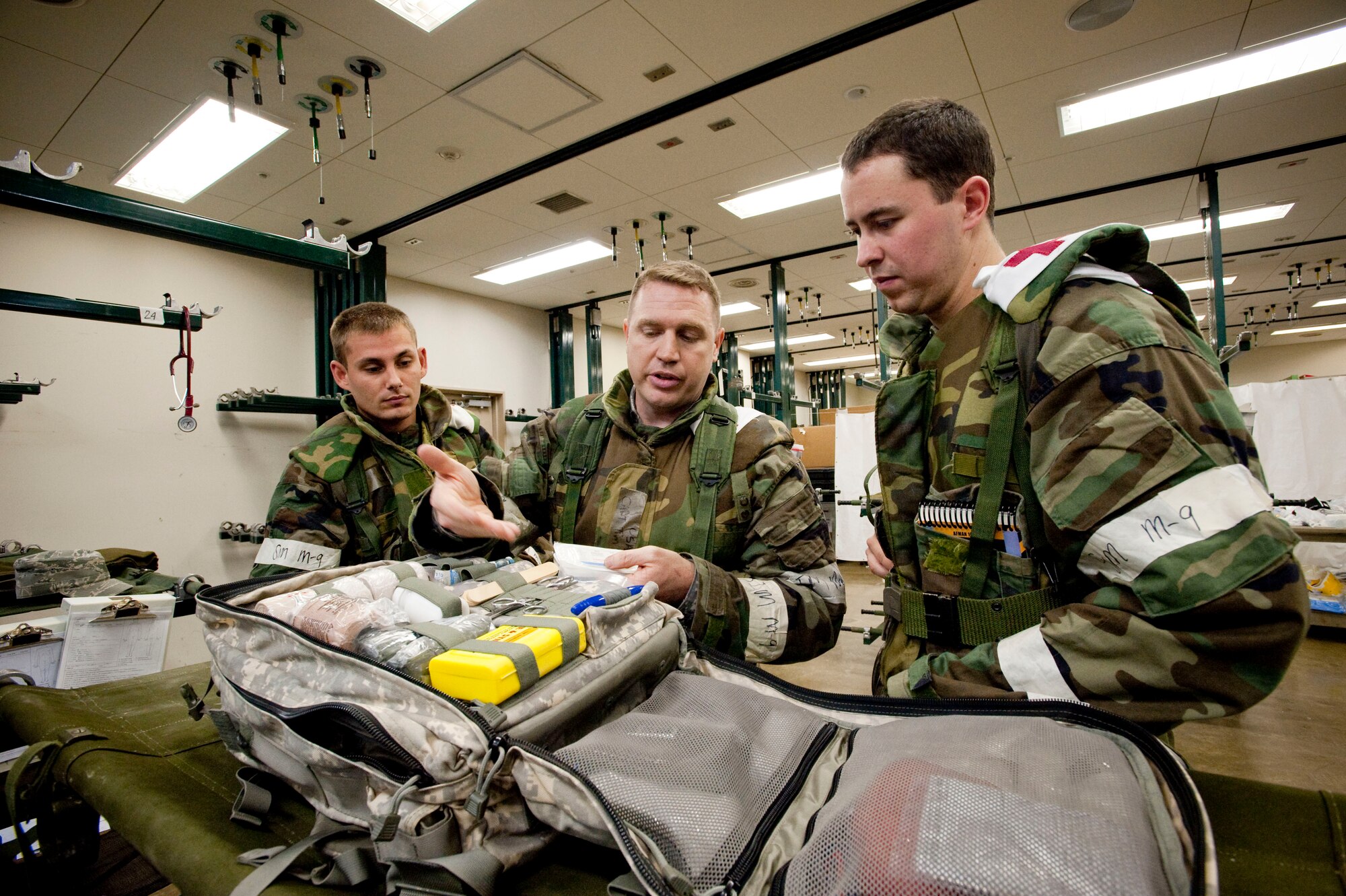MISAWA AIR BASE, Japan -- Capt. Tim Harrelson, 35th Medical Operations Squadron family practice physician, reviews an emergency kit with two Airmen from the 35th MDOS in the 35th Medical Group bed expansion section during a combat execution readiness exercise Sep. 2. Exercises such as this, offer a unique opportunity for more experienced Airmen to convey their knowledge and experience to the younger Airmen. (U.S. Air Force photo/Staff Sgt. Samuel Morse)