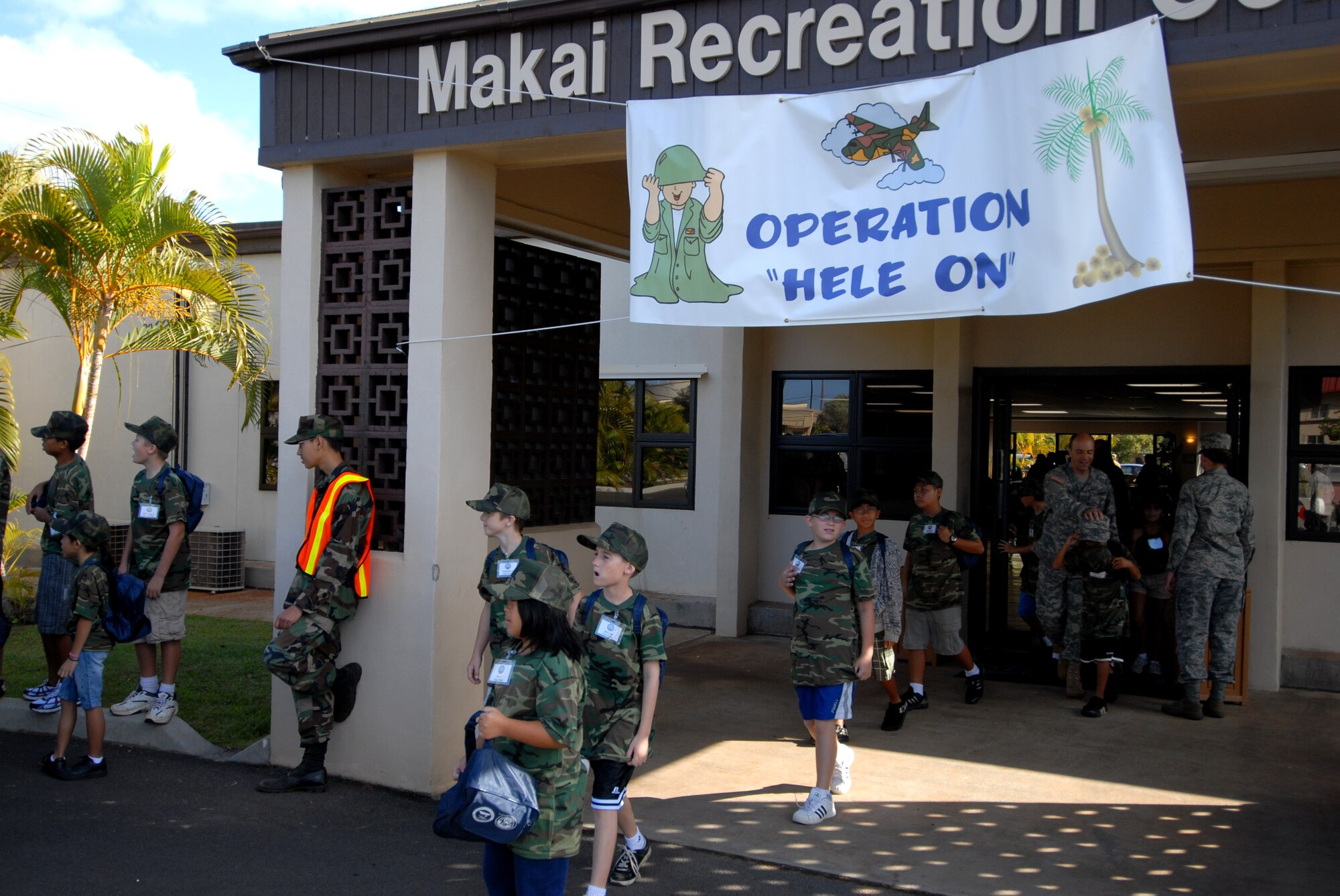 HICKAM AIR FORCE BASE, HAWAII -- Elementry school students walk to the parking lot of the Makai Recreation Center during the sixth annual Operation Hele On, Aug. 21. Hele On is a program meant to give children of military members an idea of what goes on during a deployment. During the event, kids learned how to march, were issued mobility bags, and were bussed out to the Hickam flight line to tour a C-17 Globemaster III to simulate a deployment. (U.S. Air Force photo/Senior Airman Gustavo Gonzalez)