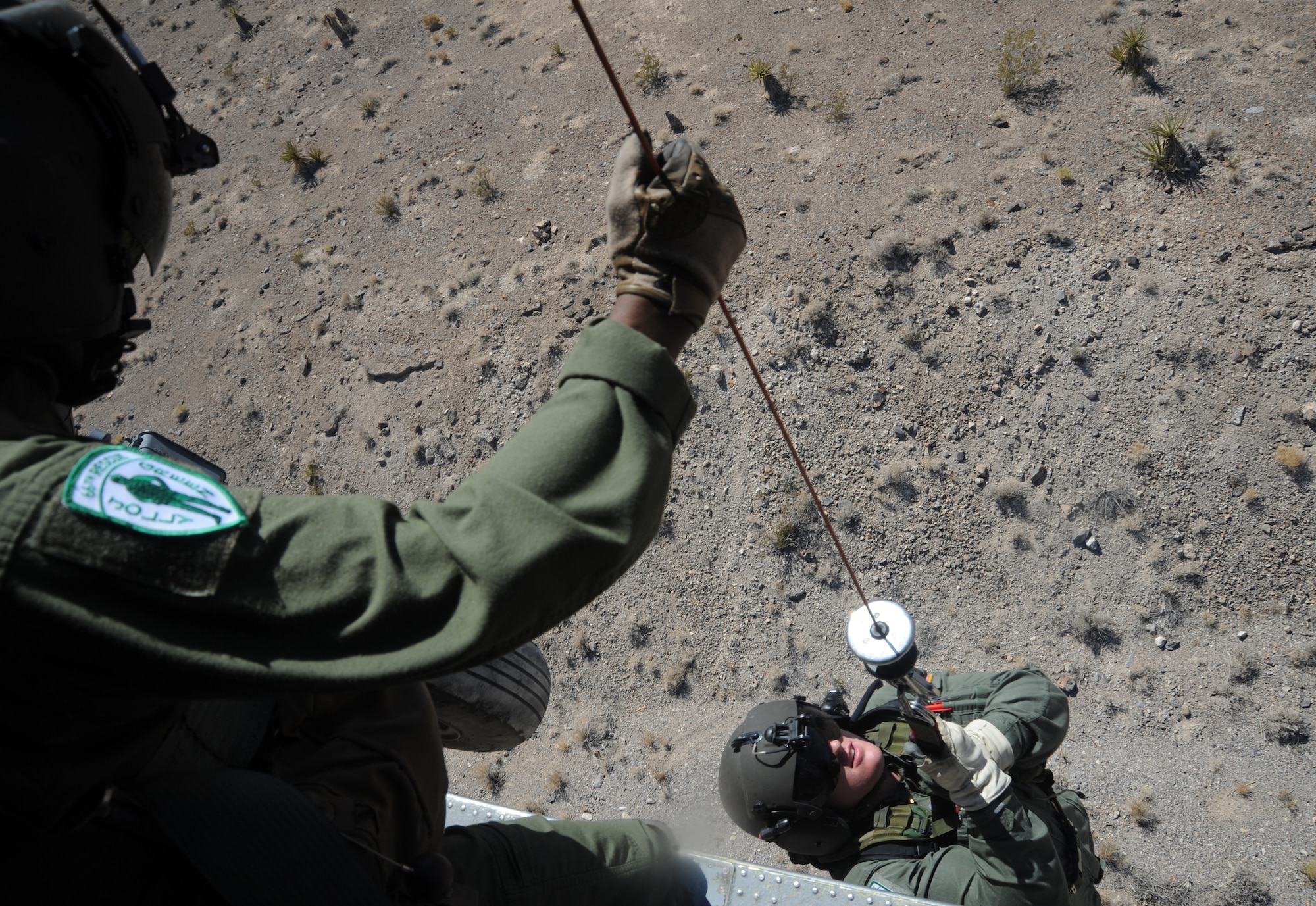 (left) Tech. Sgt. Mark Moore operates a breeze eastern hoist while lifting Staff Sgt. Lane Miller into an HH-60 Pave Hawk during a rescue operation training scenario in the Nevada desert Aug. 24, 2009. Both are aerial gunners assigned to the 66th Rescue Squadron, Nellis Air Force Base, Nev. 
(U.S. Air Force photo/ Master Sgt. Kevin J. Gruenwald) 



















  












 











































  












 

























