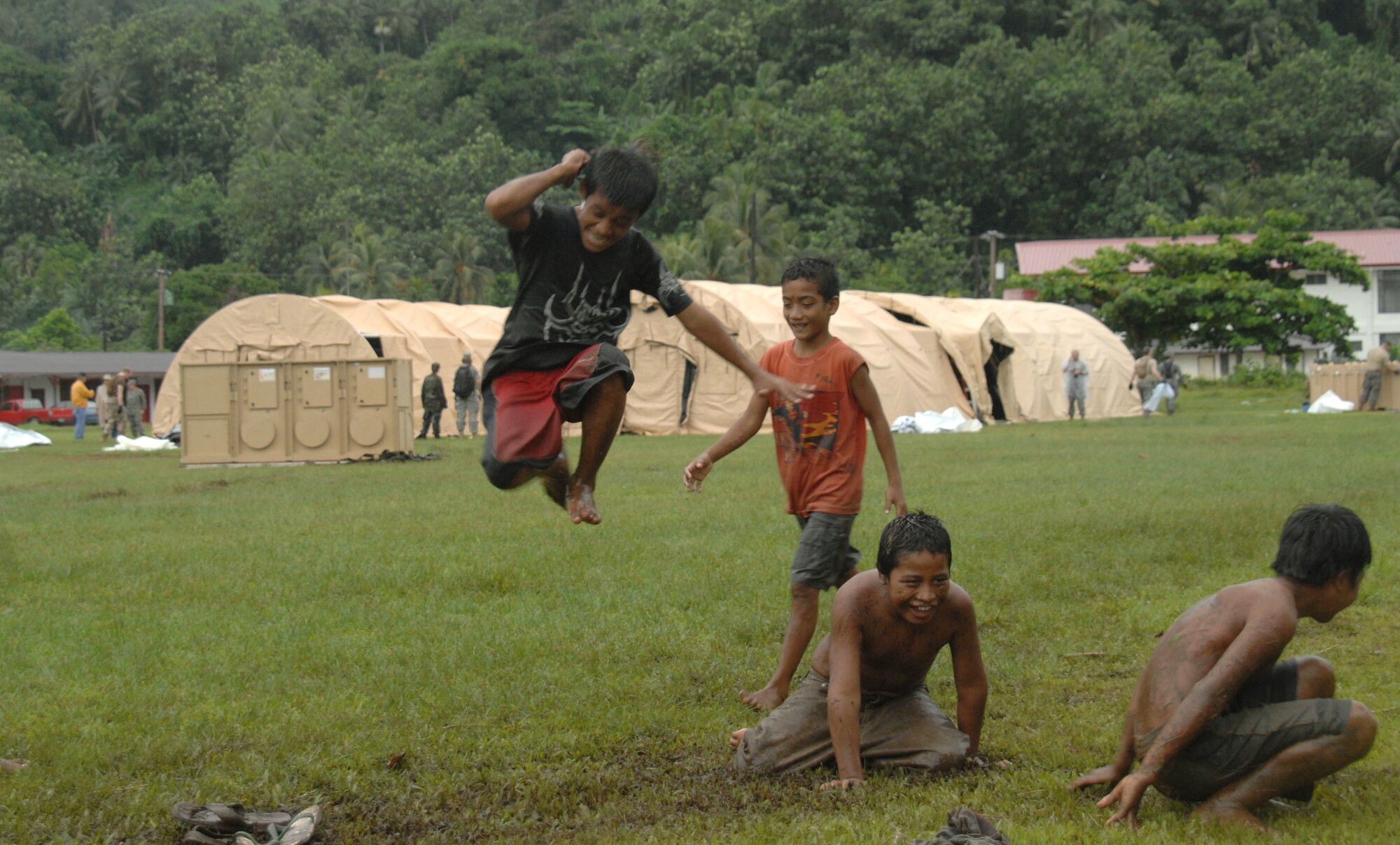 Chuukese children play while members of the Humanitarian Assistance Rapid Response Team work together to construct medical tents during a validation exercise Sept. 2 on Chuuk in the Federated States of Micronesia.  The HARRT is the Air Force?s new expeditionary medical capability designed to deploy within 24 hours of notice during disaster relief operations.  During the deployment, the team will treat 350 to 500 Chuukese patients per day.  (U.S. Air Force photo/ Capt. Andrew Hoskinson)