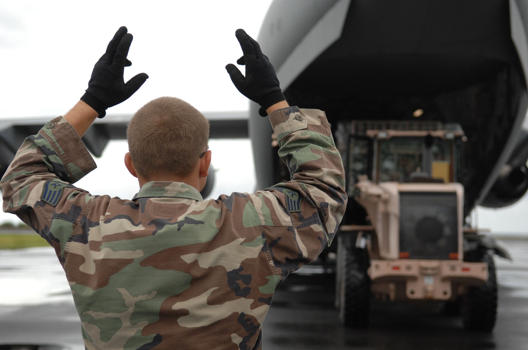 Staff Sgt. Christopher West of the 36th Contingency Response Group at Andersen Air Force Base, Guam, marshals an arriving C-17 Globemaster III Sept. 2 at the Chuuk International Airport on Weno Island, Chuuk, in the Federated States of Micronesia, during the Humanitarian Assistance Rapid Response Team validation exercise.  The HARRT is the Air Force?s new expeditionary medical capability designed to deploy within 24 hours of notice during disaster relief operations.  Based at Andersen Air Force Base, Guam, the team will provide basic medical care and assistance to 350 to 500 patients per day.  (U.S. Air Force photo/Capt. Andrew Hoskinson)