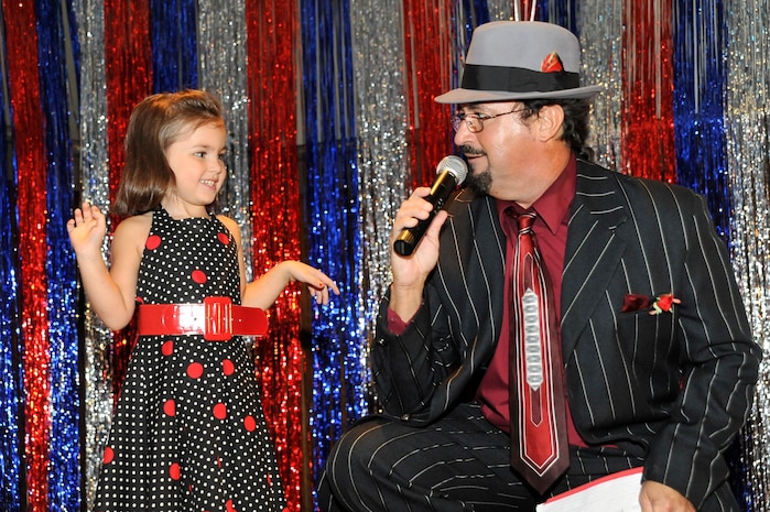 Radio Disk Jockey Rocky D. from WTMA 1250 radio asks Haley Idol questions prior to her performance at the Charleston Air Mobility Command Icon talent competition here Aug. 28. Haley is the daughter of Staff Sgt. Jeff Idol who is with the 437th Communications Squadron. (U.S. Air Force photo/James M. Bowman)

