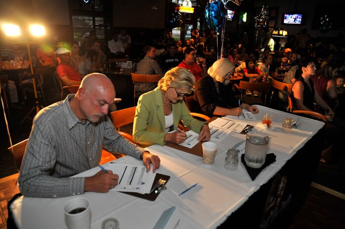 Ed Wigim, Debi Chard and Suzanne Green, who were guest judges from the local area, score the competitors during the Charleston Air Mobility Command Icon talent contest here Aug. 28. The local competitors used the karaoke-generated music, but when the finalist moves on to the AMC-level competition, the music will be provided by the Air Force Band of Mid America. (U.S. Air Force photo/James M. Bowman)