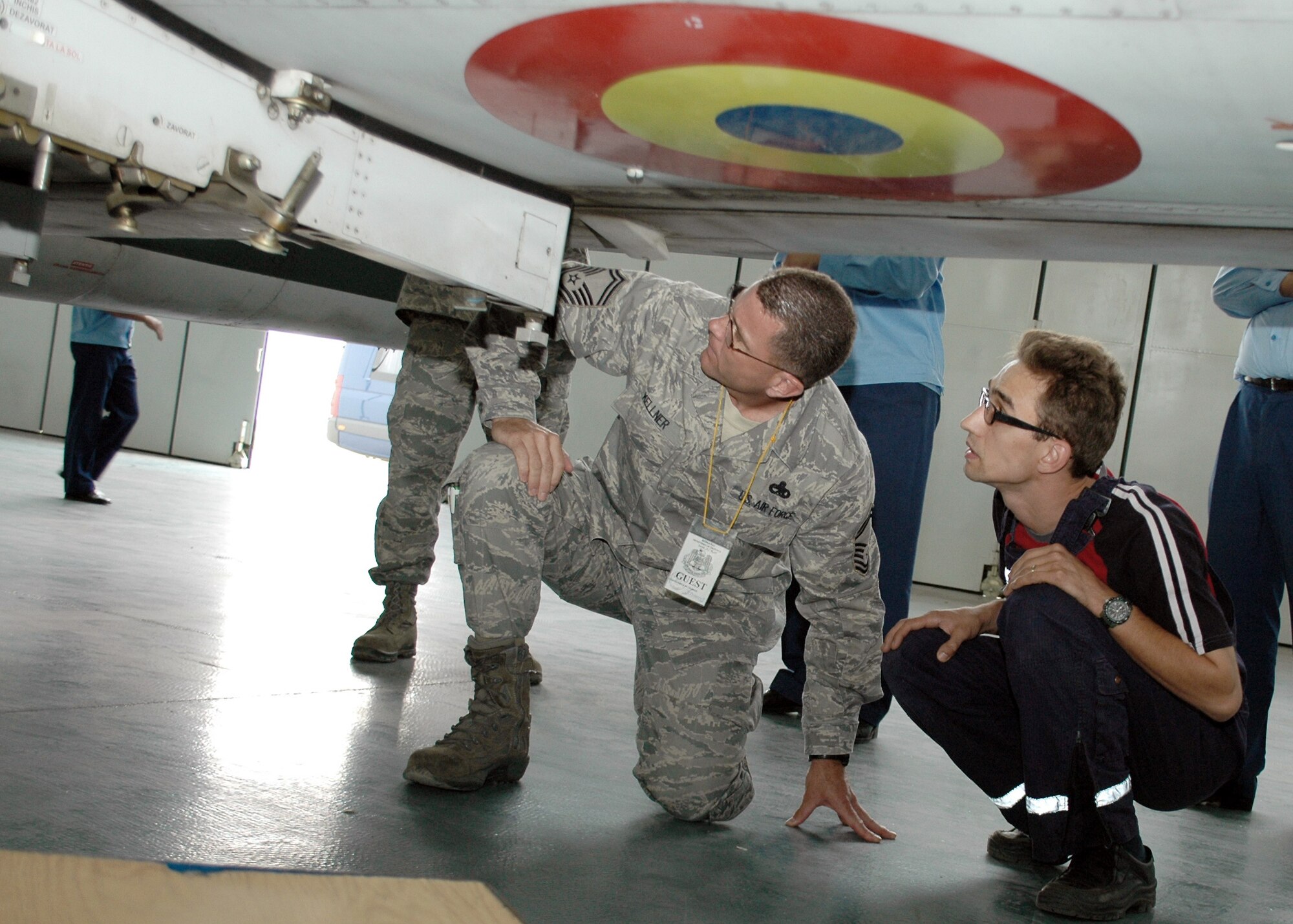 Senior Master Sgt. Timothy Kellner receives a walk-around tour of a MiG-21 Lancer Aug. 26, 2009 at the 86th Air Base in Fetesti, Romania. The tour was part of a three-person U.S. Air Forces in Europe maintenance NCO training program traveling contact team visit with Romanian air force aircraft maintainers and warrant officer and NCO school instructors Aug. 25 through 28. Sergeant Kellner is the 31st Maintenance Group quality assurance superintendent with 21 years of experience all on the F-16 Fighting Falcon. (U.S. Air Force photo/Tech. Sgt. Michael O'Connor)