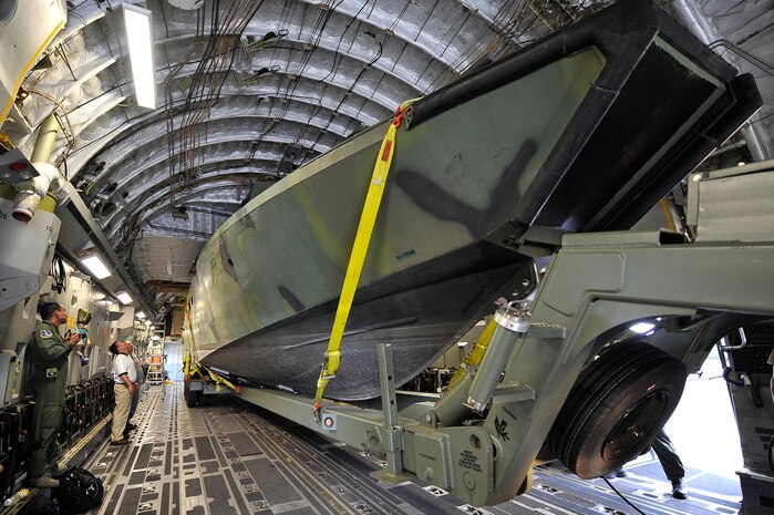 A Navy Riverine Command Boat and trailer onto a C-17 at Charleston AFB Aug. 26. The U.S. Navy's Riverine Group 1 is testing the RCB, which is designed to land on a variety of shorelines to drop off and extract personnel from any area. The RCB will be used for command and control of riverine forces in the river deltas and bays where brown water interfaces with blue water operations. (U.S. Air Force photo/James M. Bowman)