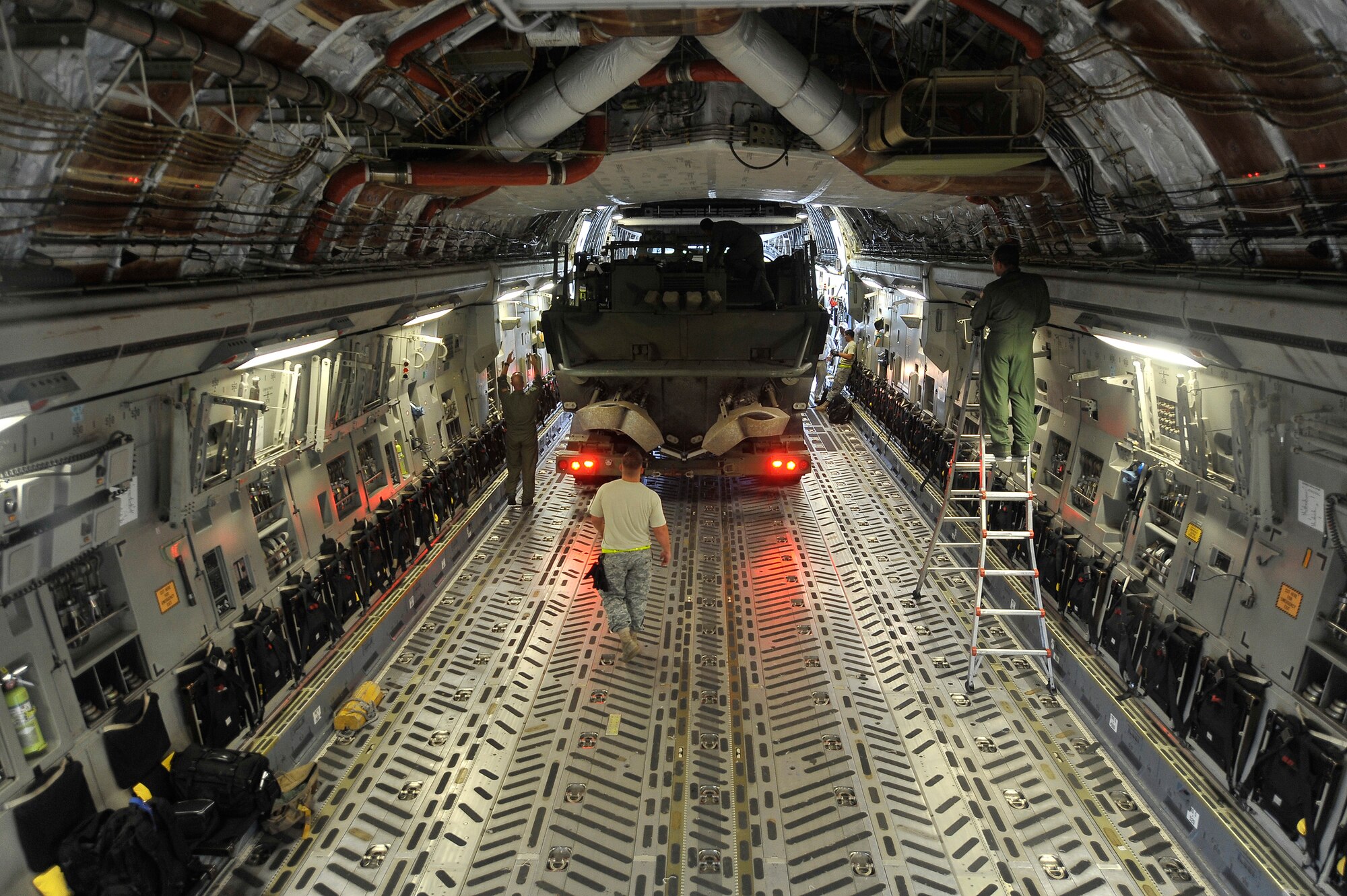 A Navy Riverine Command Boat and trailer onto a C-17 at Charleston AFB Aug. 26. The U.S. Navy's Riverine Group 1 is testing the RCB, which is designed to land on a variety of shorelines to drop off and extract personnel from any area. The RCB will be used for command and control of riverine forces in the river deltas and bays where brown water interfaces with blue water operations. (U.S. Air Force photo/James M. Bowman)