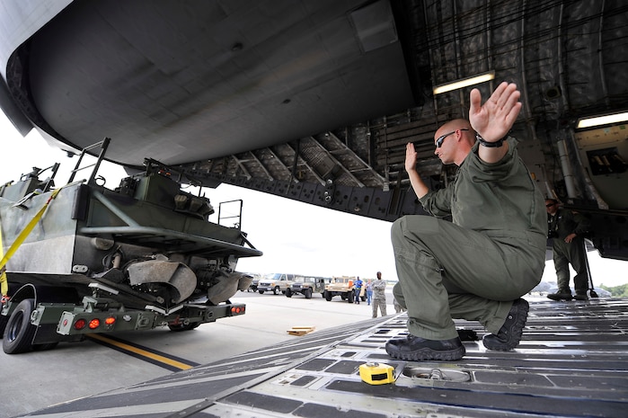 Tech. Sgt. Dave Kimberly marshals a U.S. Navy Riverine Command Boat and trailer onto a C-17 at Charleston AFB Aug. 26. The U.S. Navy's Riverine Group 1 is testing the RCB, which gives riverine squadron's a primary boat in combat missions, patrolling missions, as a combat information center which can be configured as an ambulance boat. Sergeant Kimberly is a loadmaster with the 437th Airlift  Wing standards and evaluation. (U.S. Air Force photo/James M. Bowman(