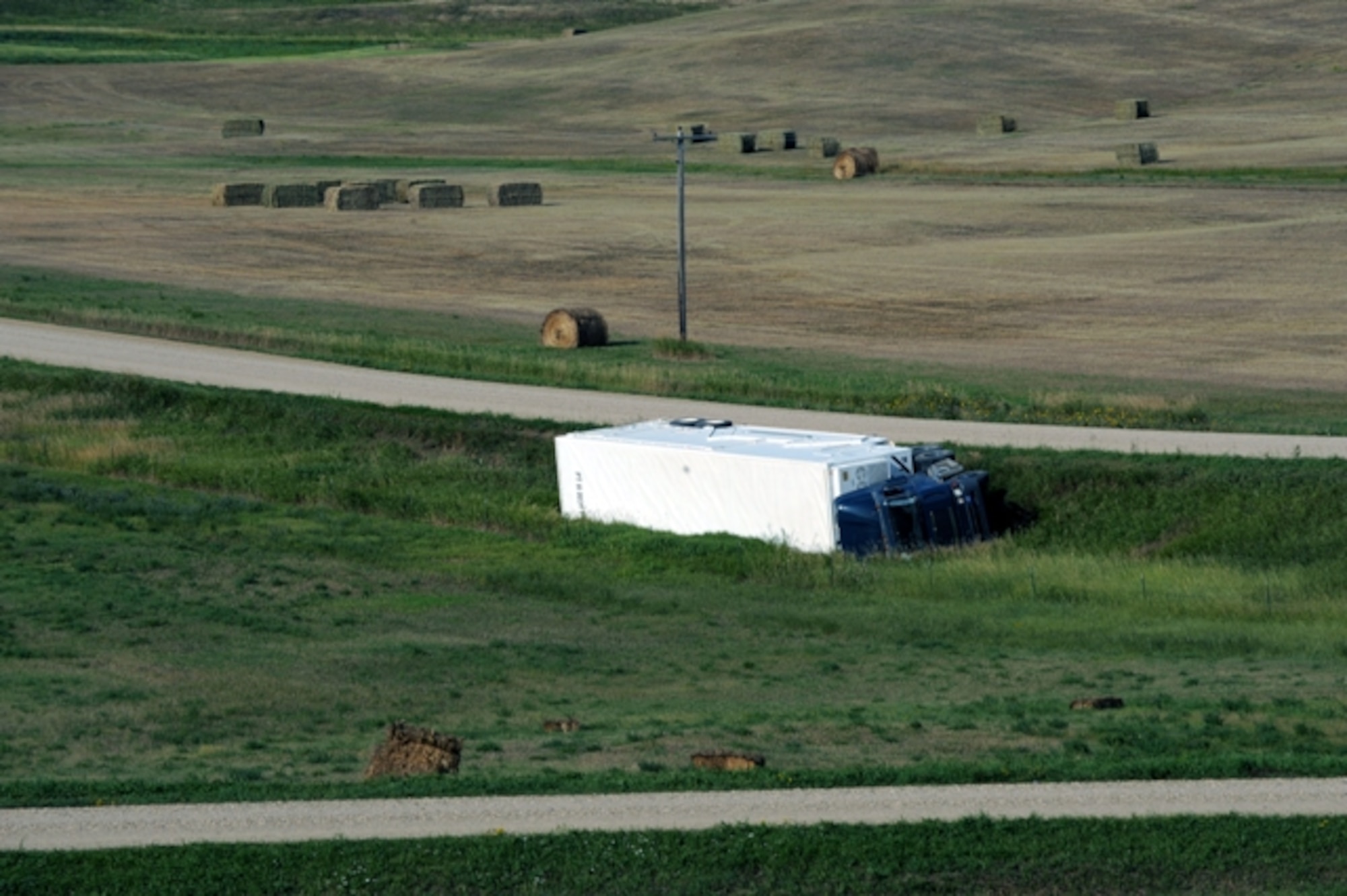 MINOT AIR FORCE BASE, N.D. -- A 91st Missile Wing payload transporter overturned about 10 miles northwest of Berthold Aug. 31. The area around the vehicle is currently secured by local law enforcement and 91st MW security forces, maintenance and safety personnel as a precautionary measure to assess and clean-up the scene. (U.S. Air Force photo by Staff Sgt. Keith Ballard)
