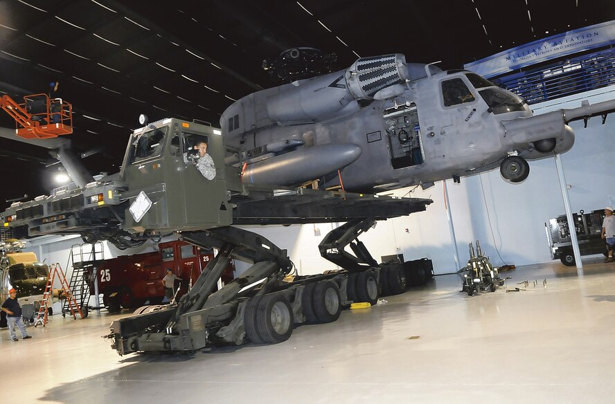 Staff Sgt. Michael Brown, 78th Logistics Readiness Squadron, operates inside the cab of a 60K loader to raise the MH-53M Pave Low IV display helicopter at the Museum of Aviation. (U. S. Air Force photo by Sue Sapp)
