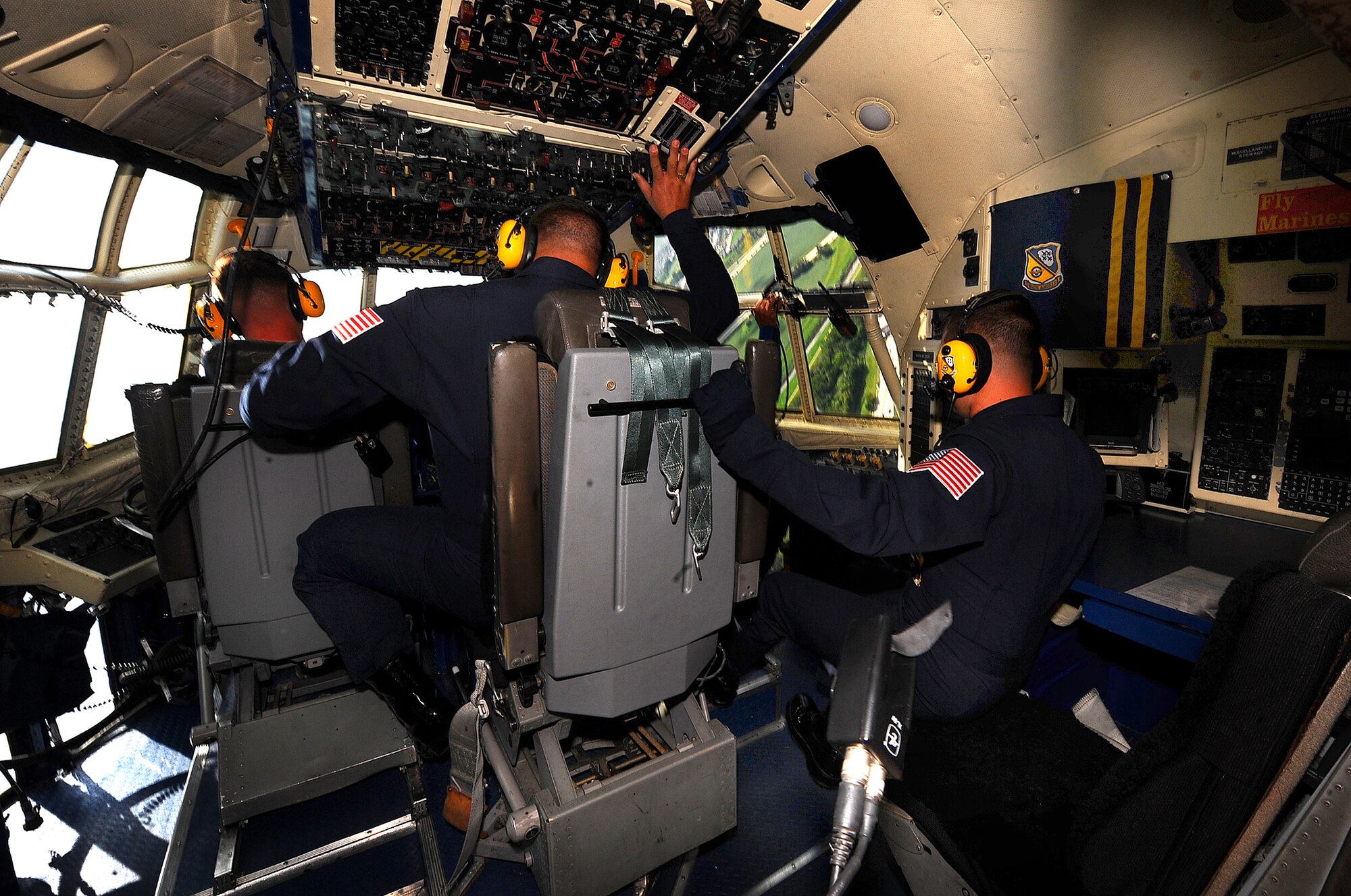 OFFUTT AIR FORCE BASE Neb. -- Members of the U.S. Navy's Blue Angels flight demonstration team inside the cockpit of the Blue Angels modified C-130 "Fat Albert," hold on to parts of the aircraft to avoid floating out of their seats as U.S. Marine Corps pilot, Maj. Drew Hess, takes a hard right turn above Offutt Aug. 28. U.S. Air Force Photo by Josh Plueger
