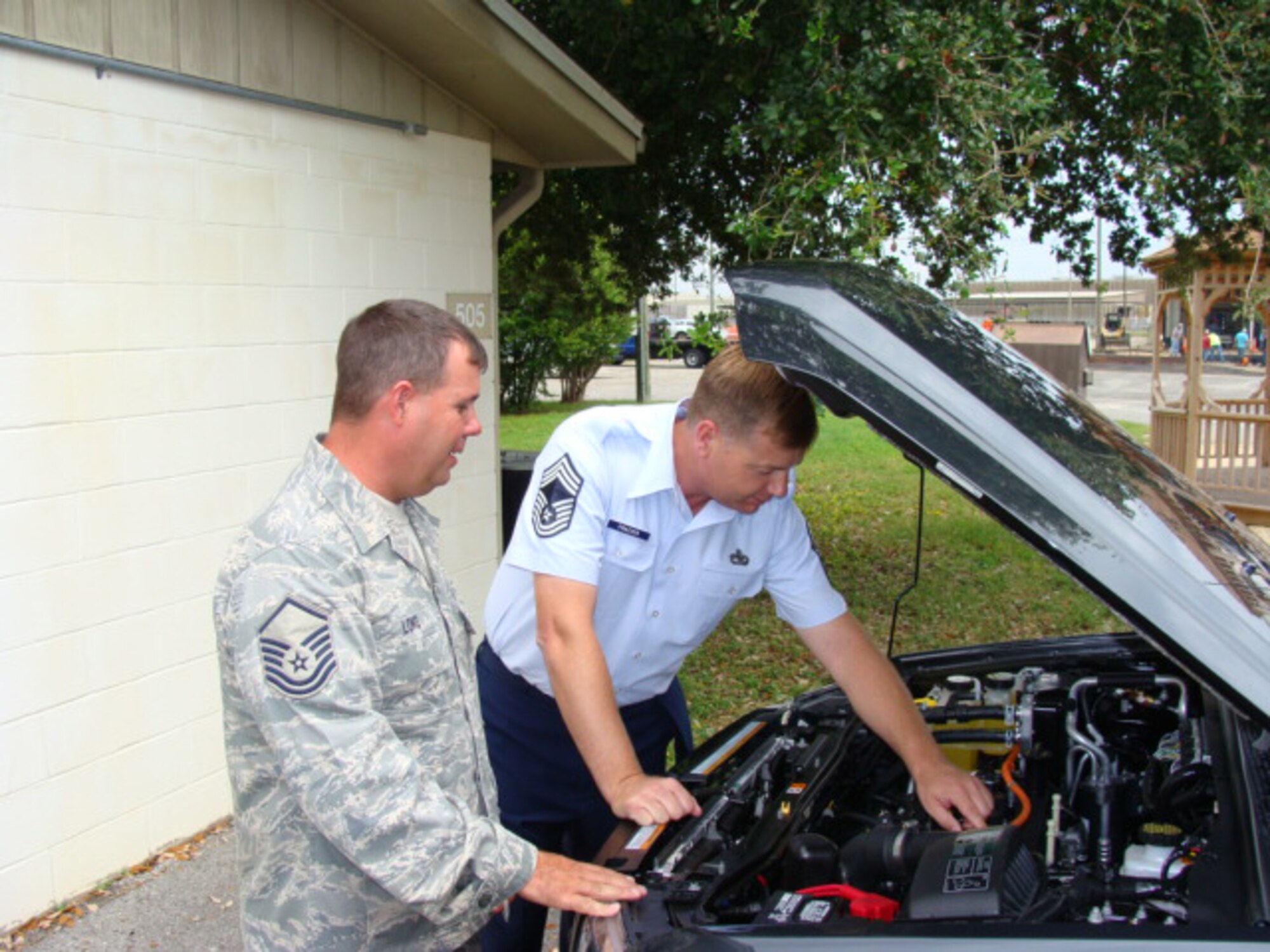 Chief Master Sgt. Daniel Frazier and Master Sgt. Johnny Long, 96 Logistic Readiness Squadron vehicle managers, discuss the advantages of a newly received hybrid vehicle. (USAF photo)                             