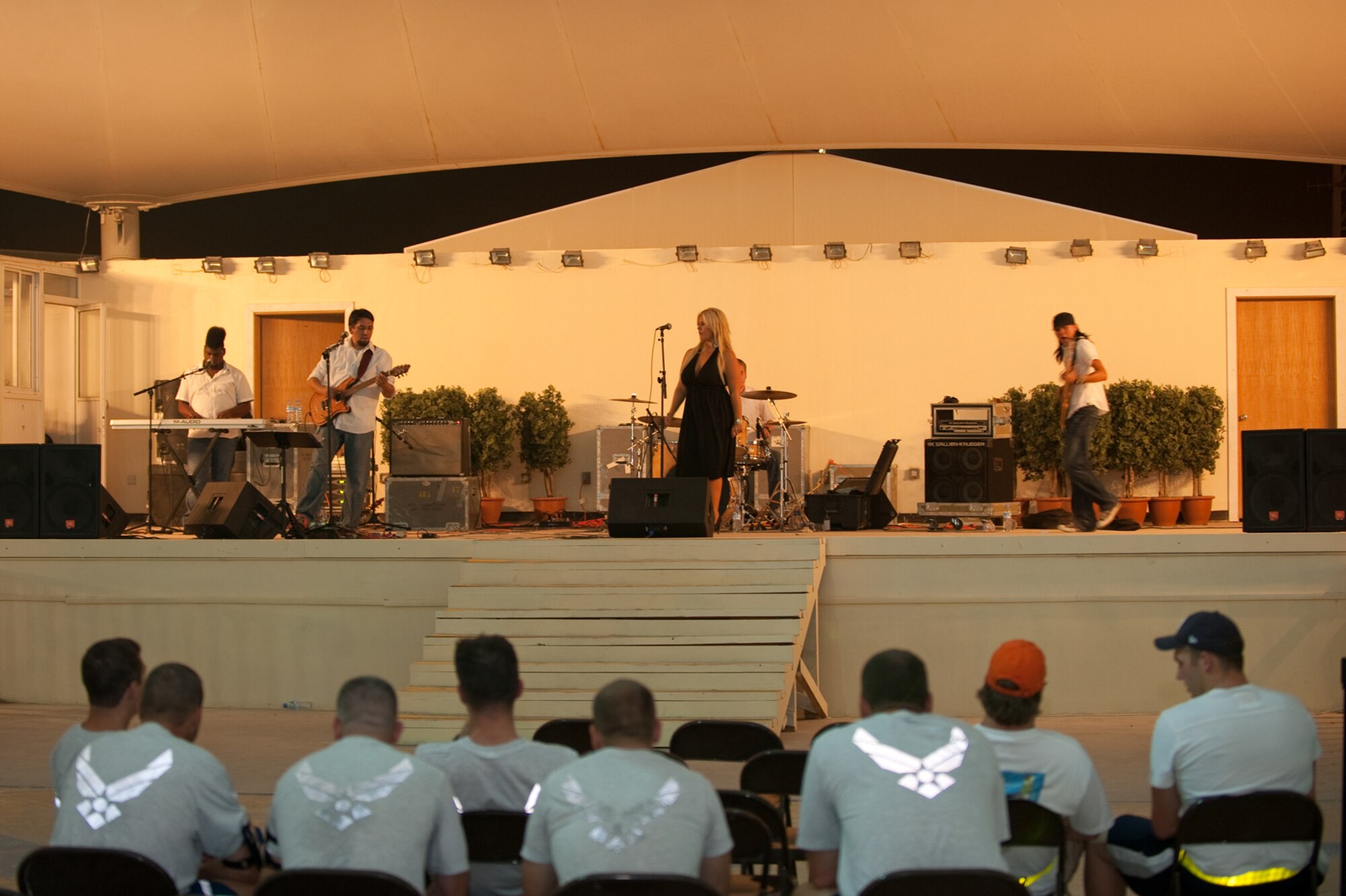 Deployed servicemembers listen to Night Shift, a southern California-based band, at an undisclosed location, Aug. 31, in Southwest Asia. Night Shift is the first U.S. band to perform here through the use of locally generated non-appropriated funds. Servicemembers are deployed in support of Operations Iraqi and Enduring Freedom. (U.S. Air Force photo/Staff Sgt. Robert Barney)