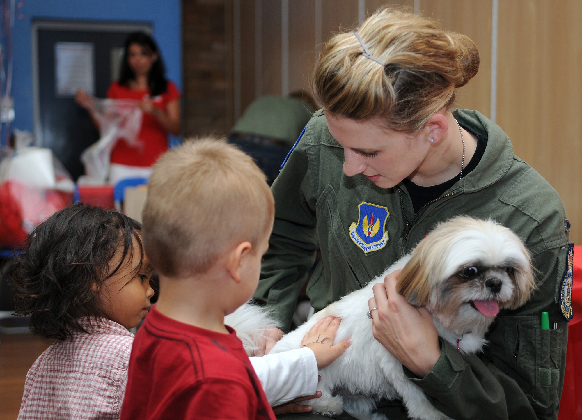 RAF MILDENHALL, England -- Children learn proper pet safety practices from 1st Lt. Natalie Winkels, 351st Air Refueling Squadron, at a Kids' Safety Day hosted by the American Red Cross Aug. 27 at the Bob Hope Community Center. Lieutenant Winkels volunteered to run a pet safety booth to show children how to safely approach an animal they do not know. "Kids don't always realize that just because a dog is small, that it can be dangerous, too," she said. (U.S. Air Force photo/Senior Airman Thomas Trower)