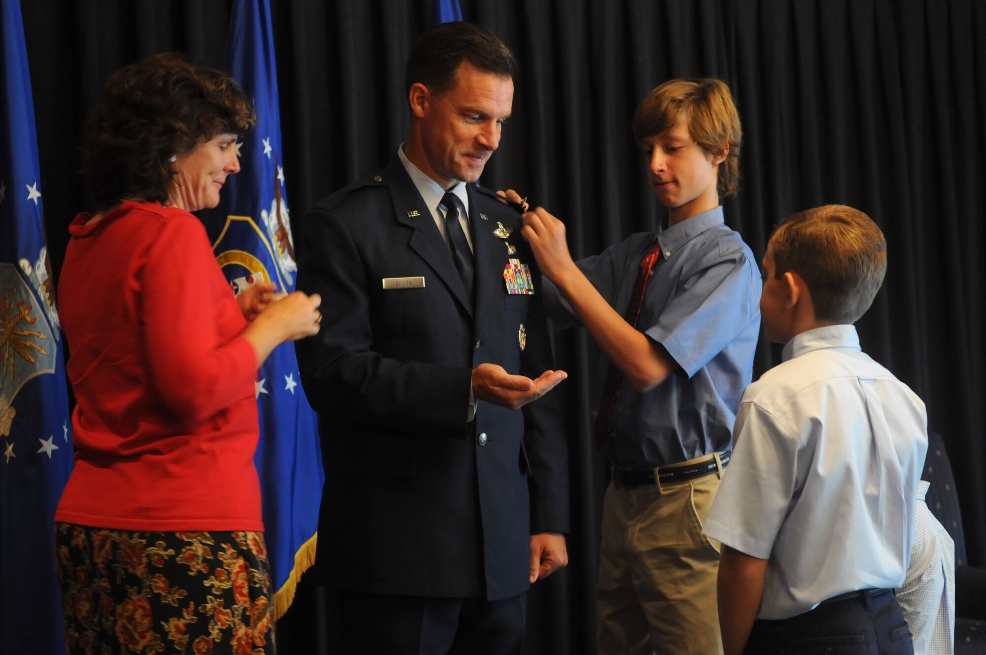 Brig. Gen. Mark Dillon receives his new rank from his family during his promotion ceremony at the Officer's Club on Ramstein Air Base, Germany, Sept. 2. Assisting in the pin on where his wife, Sarah, and sons Charlie, Jack and Luke. (U.S. Air Force photo by Staff Sgt. Charity Barrett)