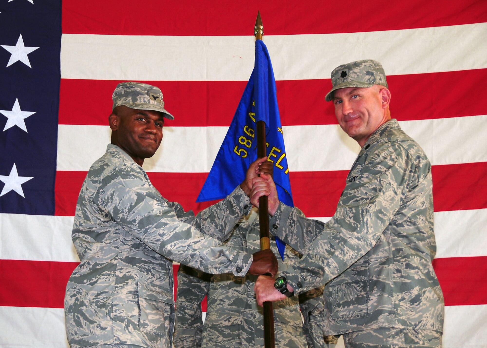 SOUTHWEST ASIA -- Lt. Col. David Barna assumes command of the 586th Expeditionary Logistics Readiness Squadron by accepting the guidon from Col. John Williams, 586th Air Expeditionary Group commander, during a change of command ceremony in an undisclosed location in Southwest Asia Sept. 2, 2009.  (U.S. Air Force photo/Tech. Sgt. Tony Tolley)