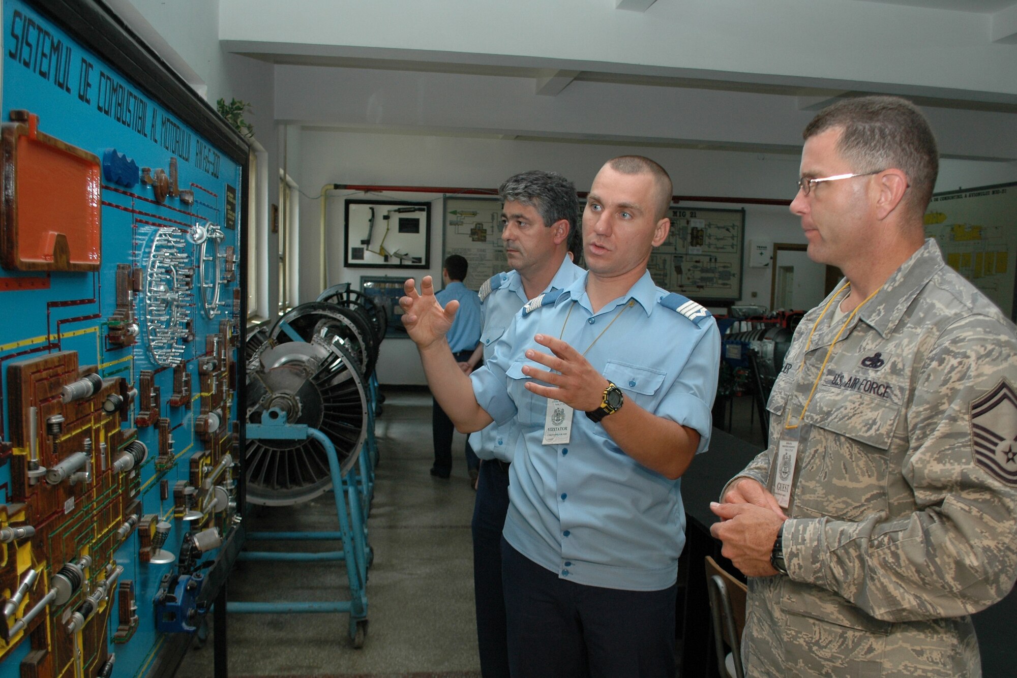 Romanian Air Force Warrant Officer Second Class Dima Valentin, (middle), a MiG-21 Lancer electrician by trade, discusses an aircraft maintenance diagram Aug. 25, 2009, with Senior Master Sgt. Timothy Kellner, 31st Maintenance Group quality assurance superintendent.  Sergeant Kellner’s visit to the Traian Vuia Air Force Warrant Officer and NCO Military School in Boboc, Romania, is part of a three-person U.S. Air Forces in Europe Maintenance NCO Training Program Traveling Contact Team who met with RoAF aircraft maintainers and WO and NCO school instructors Aug. 25-28.  (U.S. Air Force photo/Tech. Sgt. Michael O’Connor)