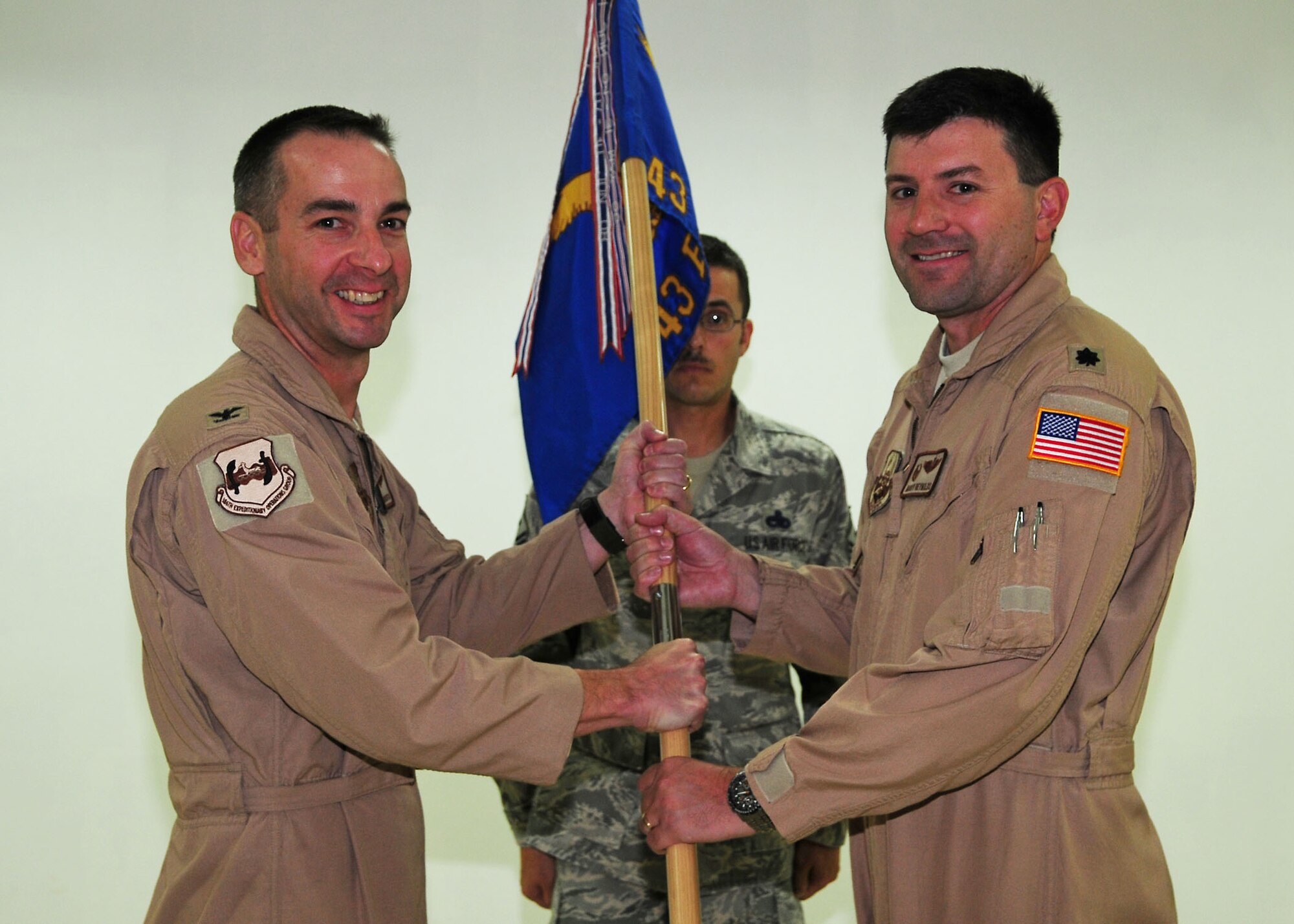 SOUTHWEST ASIA -- Lt. Col. George Reynolds assumes command of the 43rd Expeditionary Electronic Combat Squadron, by accepting the guidon from Col. Mark Czelusta, 386th Expeditionary Operations Group commander, during a change of command ceremony in Southwest Asia Sept. 1, 2009.  (U.S. Air Force photo/Tech. Sgt. Tony Tolley)