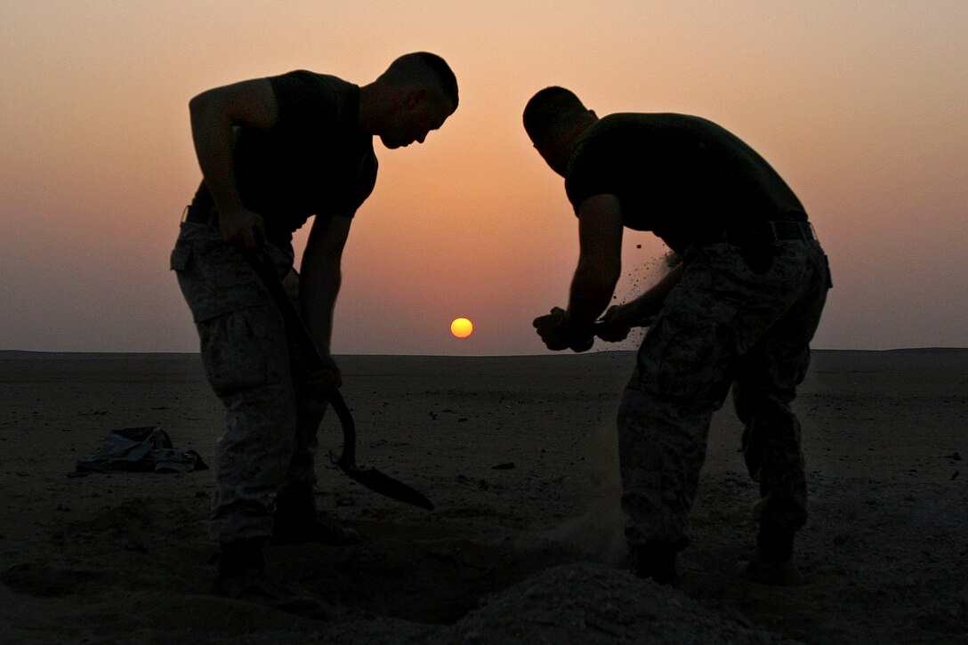 U.S. Marines dig holes for a 55-gallon improvised flame mine during a combat engineer demolition course at a training area near Camp Buehring, Kuwait, Aug. 27, 2009.