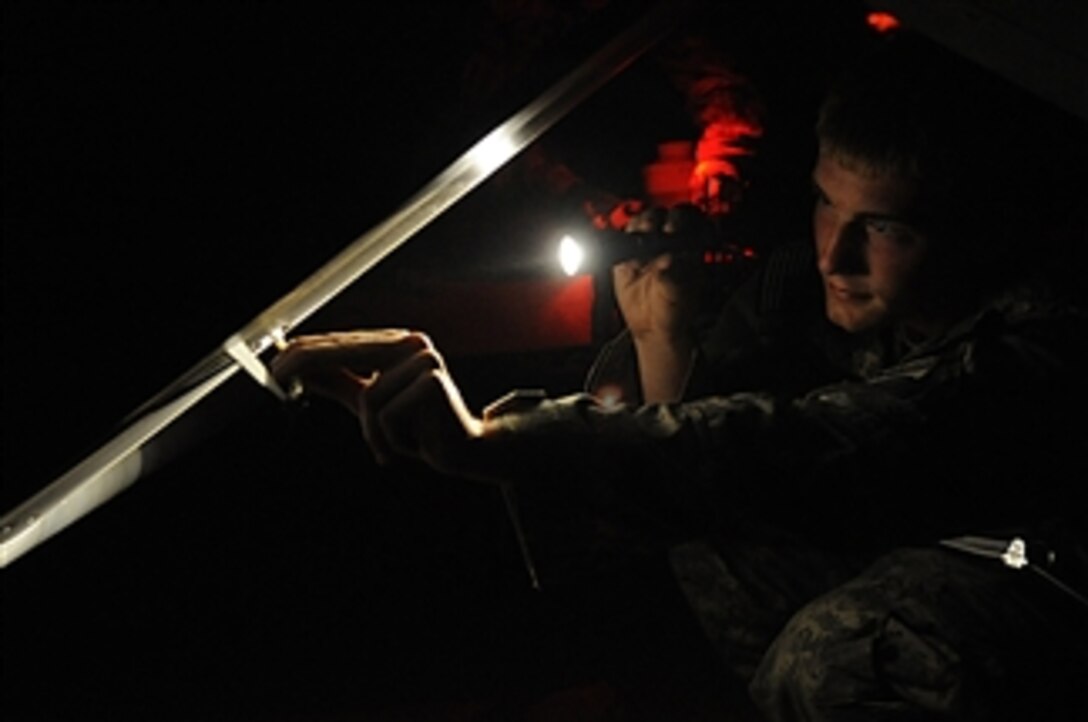 U.S. Army Spc. Frank Winspear, an unmanned aerial vehicle operator with the Special Troops Battalion, 2nd Brigade Combat Team, 82nd Airborne Division, Fort Bragg, N.C., performs a maintenance check on an unmanned aerial vehicle at Pope Air Force Base, N.C., on Aug. 27, 2009.  