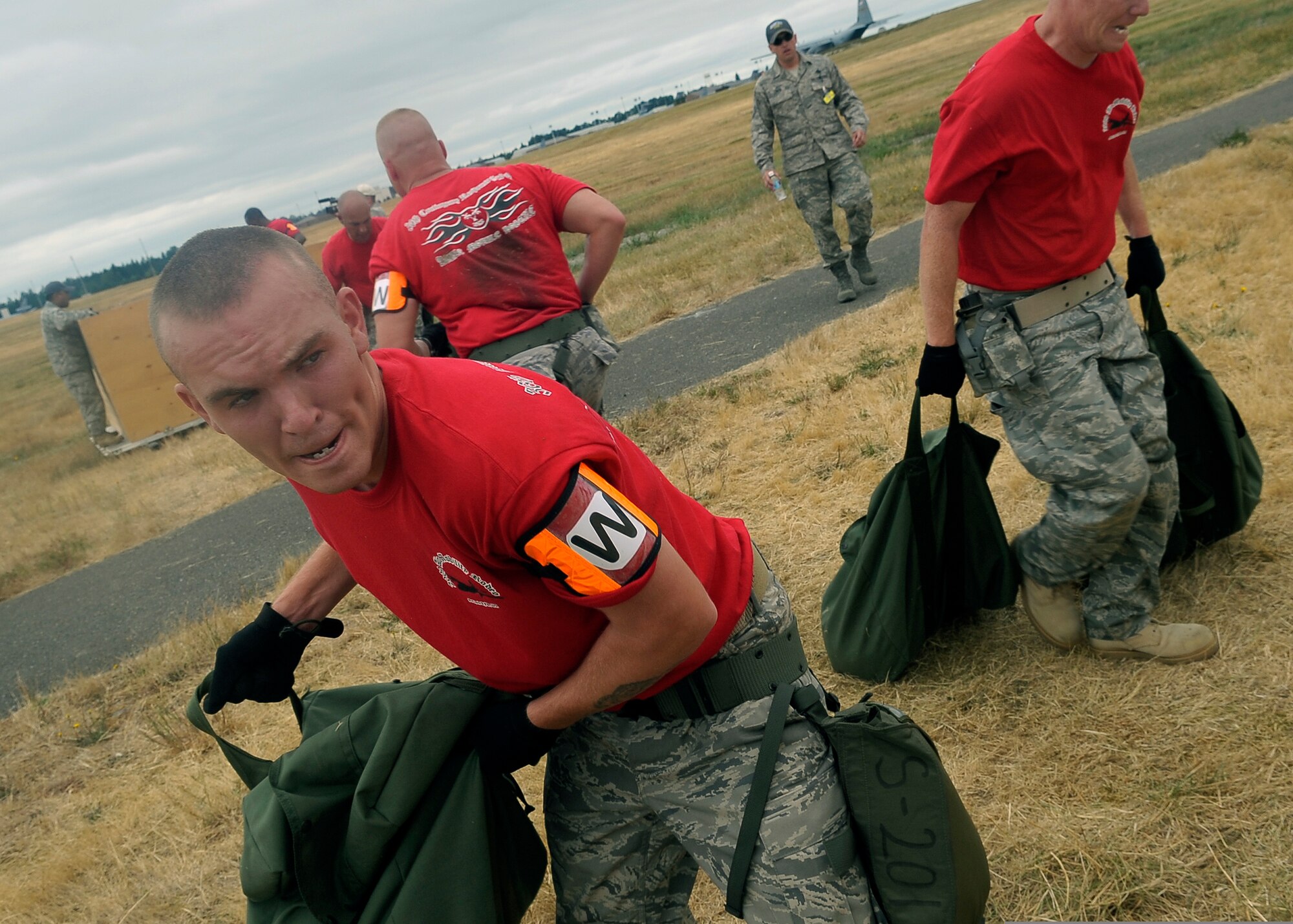 Airmen with the 36th Wing, Andersen Air Force Base, Guam, toss 45-pound sandbags from one crate to another as part of an Aerial Port competition. (U.S. Air Force photo by Senior Airman Dayton Mitchell)