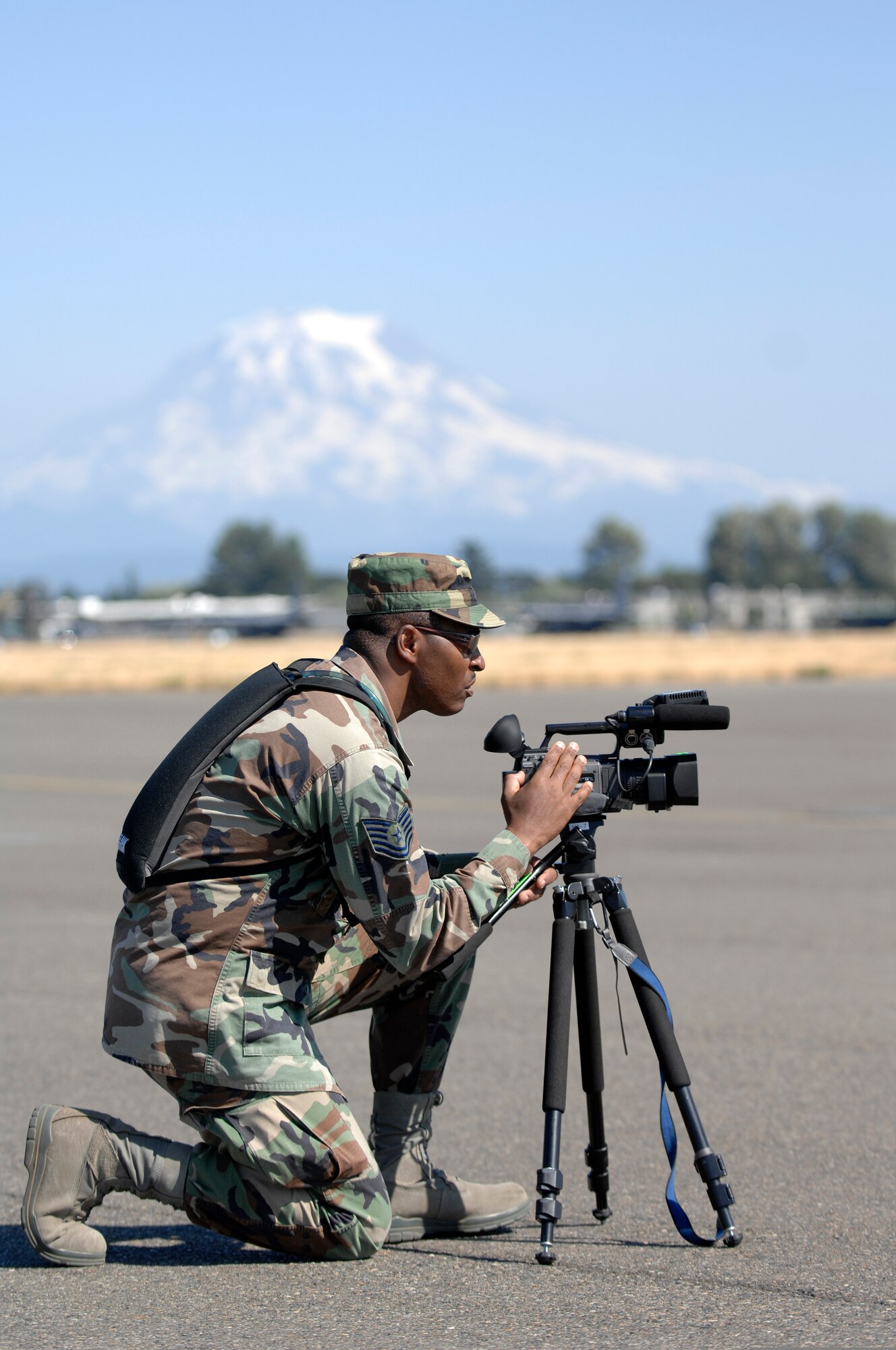 U.S. Air Force Tech. Sgt. Jerome Turner of March ARB Fourth Combat Camera Squadron shoots video during Air Mobility Rodeo 2009 at McChord Air Force Base, Wash. Mount Rainier looms in the background. (U.S. Air Force photo by Senior Airman Matthew Smith)