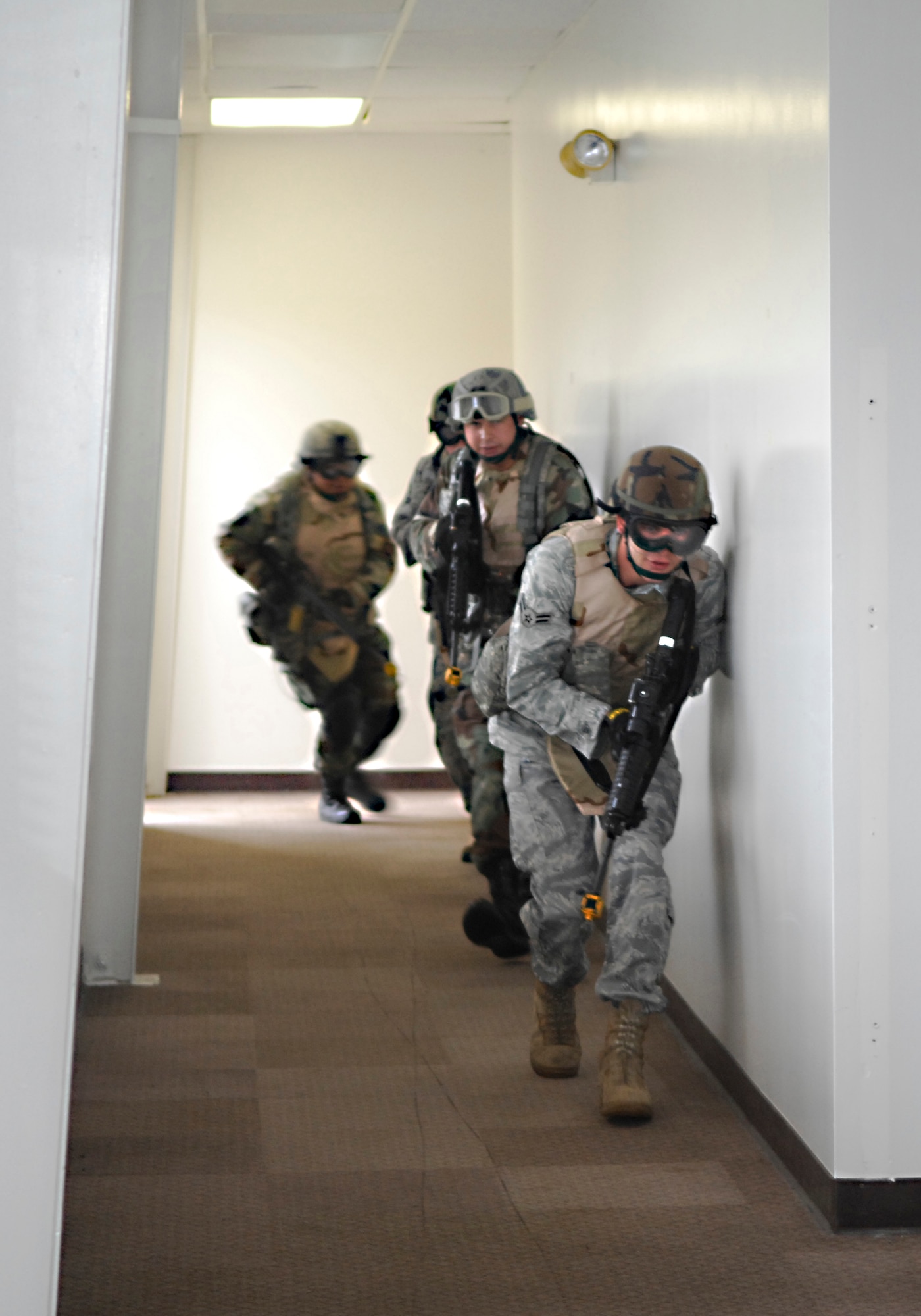 VANDENBERG AIR FORCE BASE, Calif. --  Moving as a team, members of the 30th Security Forces Squadron enter an unsecure room prepared for a hostile environment during training here Aug. 18. Each of the squadron's four flights attend monthly training sessions in an effort to always remain prepared. (U.S. Air Force photo/Airman 1st Class Heather R. Shaw)