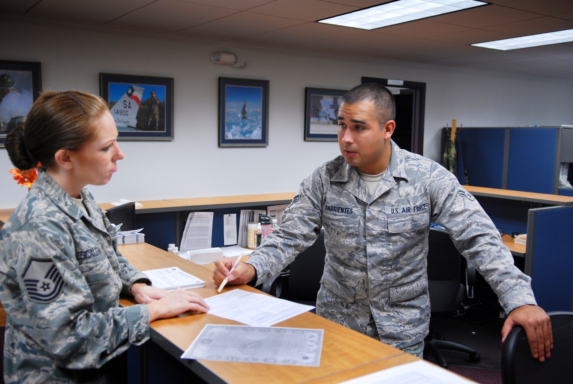 Airman 1st Class Kris Barrientes, a financial service technician with the Texas Air National Guard's 149th Fighter Wing, provides customer service to Master Sgt Carri Escalera, the noncommissioned officer in-charge of the Air National Guard installation's personnel readiness section, at Lackland Air Force Base, Texas, on September 3, 2009. (U.S. Air Force photo/Staff Sgt Eric L. Wilson)