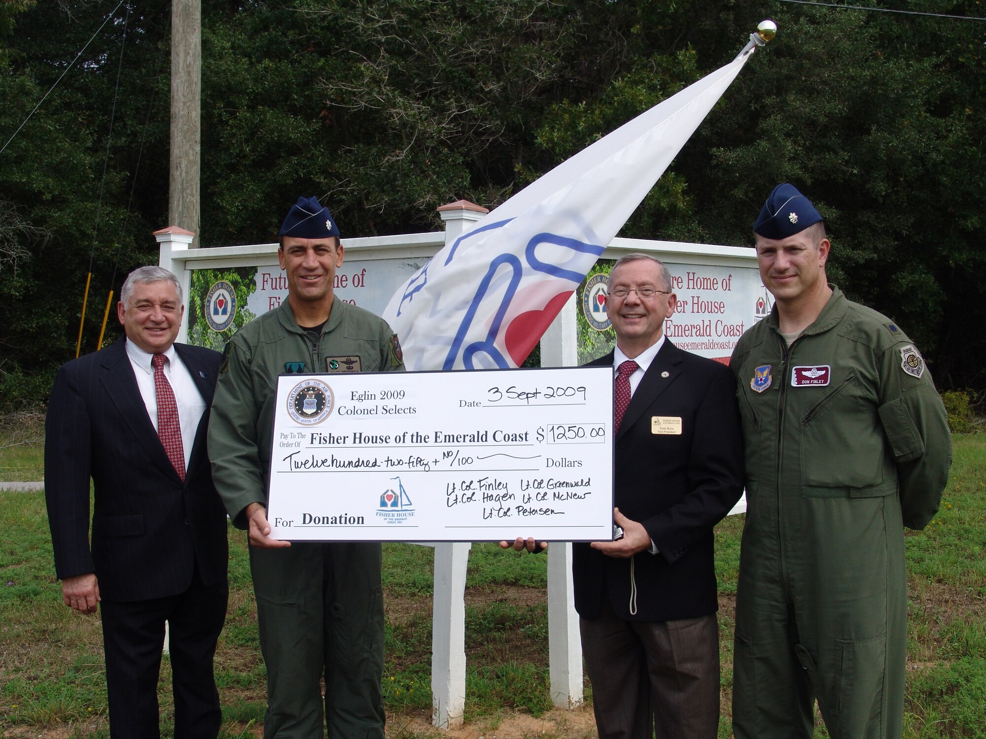 Fisher House board members Ken Walsh and Tom Rice accept a donation from Lt. Col. Charles Greenwald and Donald Finley.  The colonels, along with other selects, Gregory McNew, Mel Petersen, and Doug Hagen used funds for their promotion parties to support Fisher House. (U.S. Air Force photo/Lois Walsh)