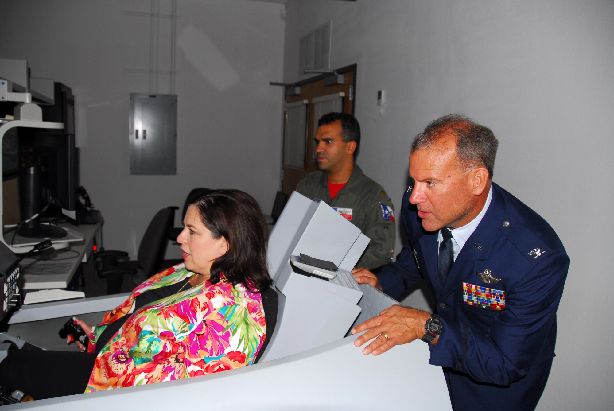 Col. Kenneth Nereson, commander of the Texas Air National Guard's 149th Fighter Wing, watches State Sen. Leticia Van de Putte, of San Antonio, simulate flight in an F-16 trainer at Lackland Air Force Base, Texas, on August 28, 2009. (U.S. Air Force photo/Staff Sgt Phil Fountain)